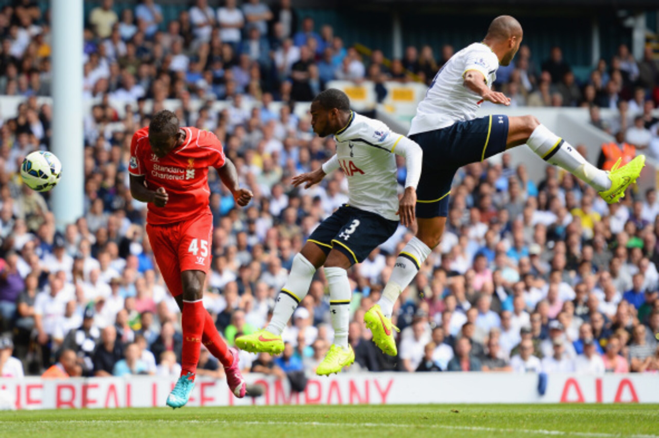 LONDON, ENGLAND - AUGUST 31:  Mario Balotelli of Liverpool heads the ball under pressure from Danny Rose and Younes Kaboul of Spurs during the Barclays Premier League match between Tottenham Hotspur and Liverpool at White Hart Lane on August 31, 2014 in L