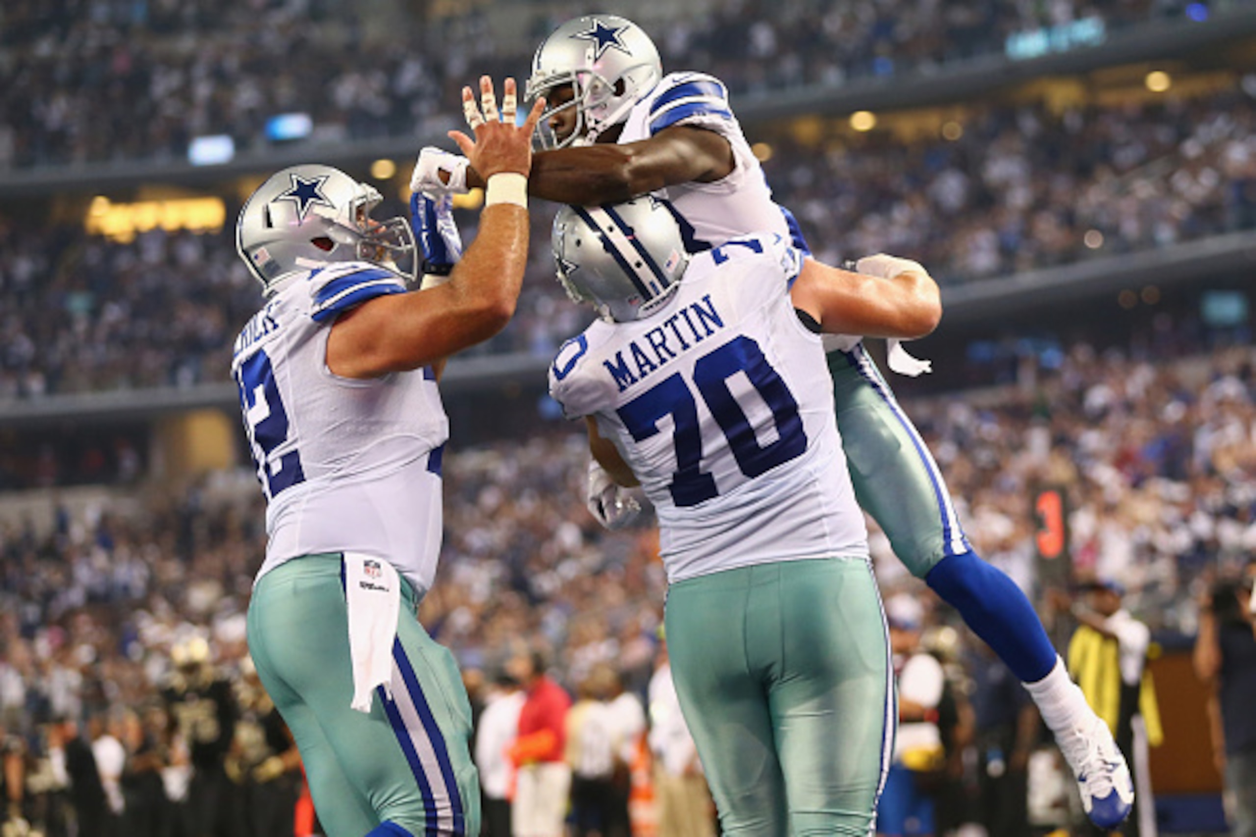 ARLINGTON, TX - SEPTEMBER 28:  Dez Bryant #88 of the Dallas Cowboys celebrates a touchdown with  Zack Martin #70 and Travis Frederick #72 against the New Orleans Saints at AT&T Stadium on September 28, 2014 in Arlington, Texas.  (Photo by Ronald Martinez/