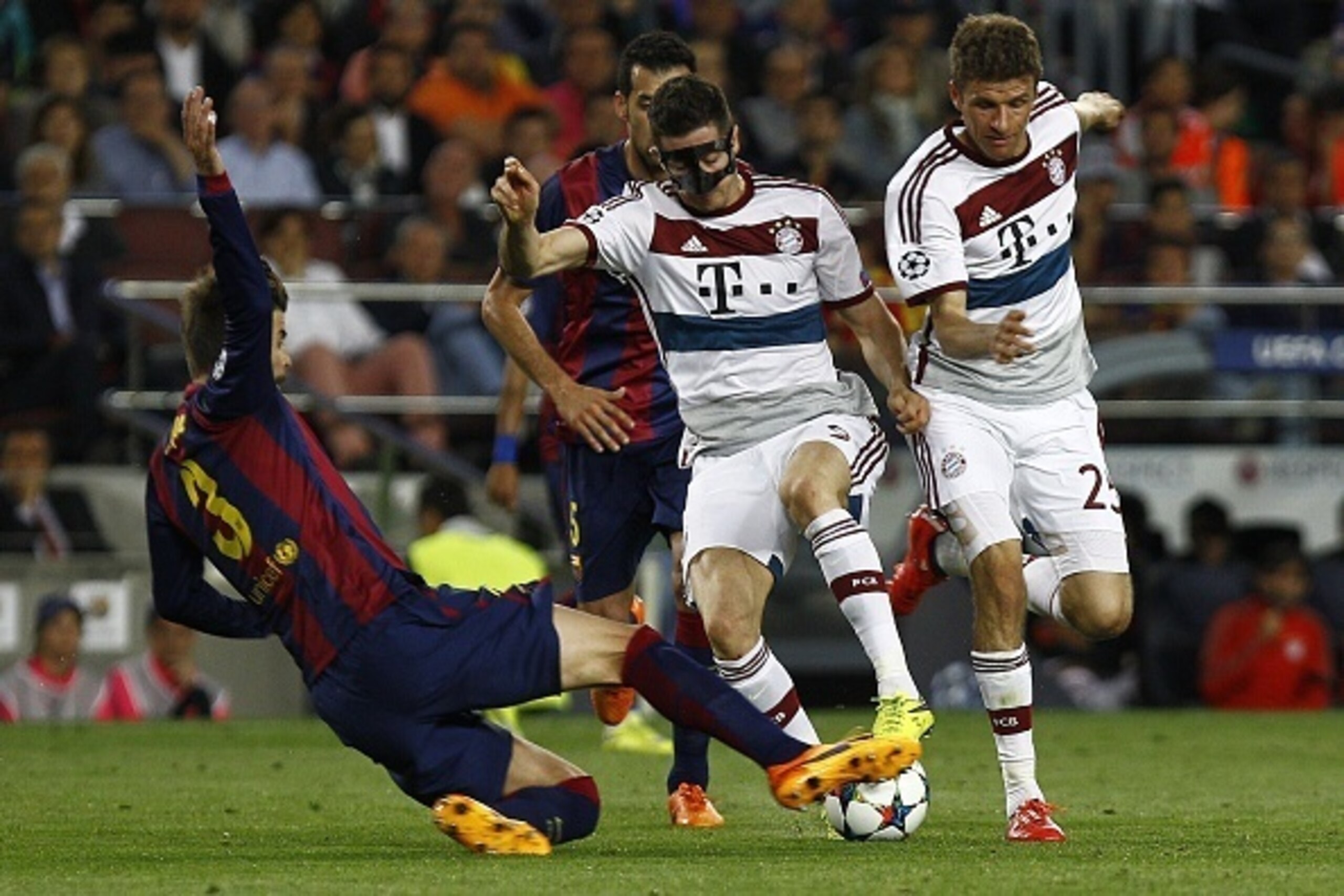 Bayern Munich's Polish forward Robert Lewandowski (C) is tackled by Barcelona's defender Gerard Pique (L) next to Bayern Munich's forward Thomas Mueller during the UEFA Champions League football match FC Barcelona vs FC Bayern Muenchen at the Camp Nou sta