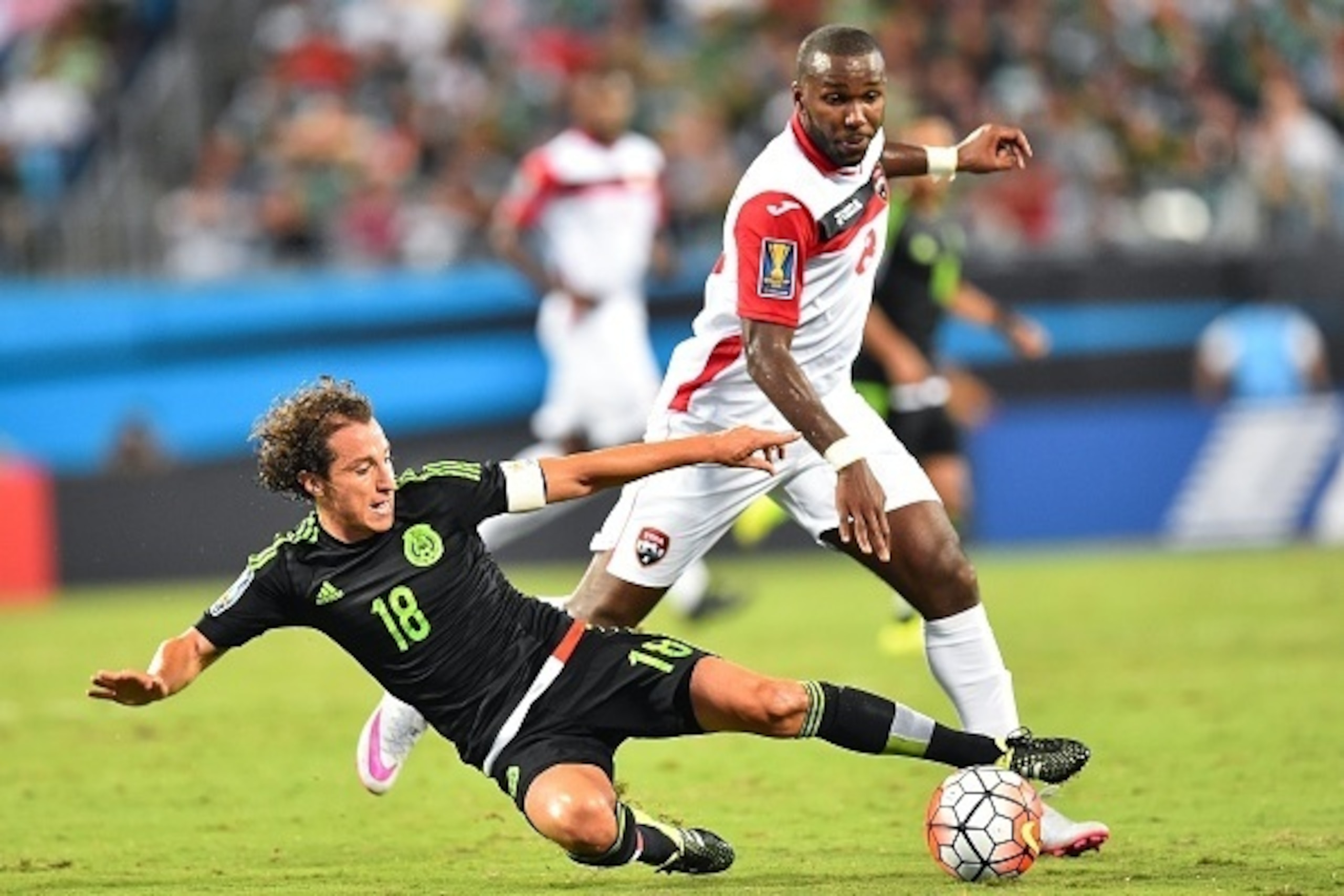 Mexico's Andres Guardado (front) fights for the ball with Trinidad and Tobago's Khaleem Hyland during a CONCACAF Gold Cup Group C match  in Charlotte, North Carolina, on July 15, 2015.    AFP PHOTO/NICHOLAS KAMM        (Photo credit should read NICHOLAS K