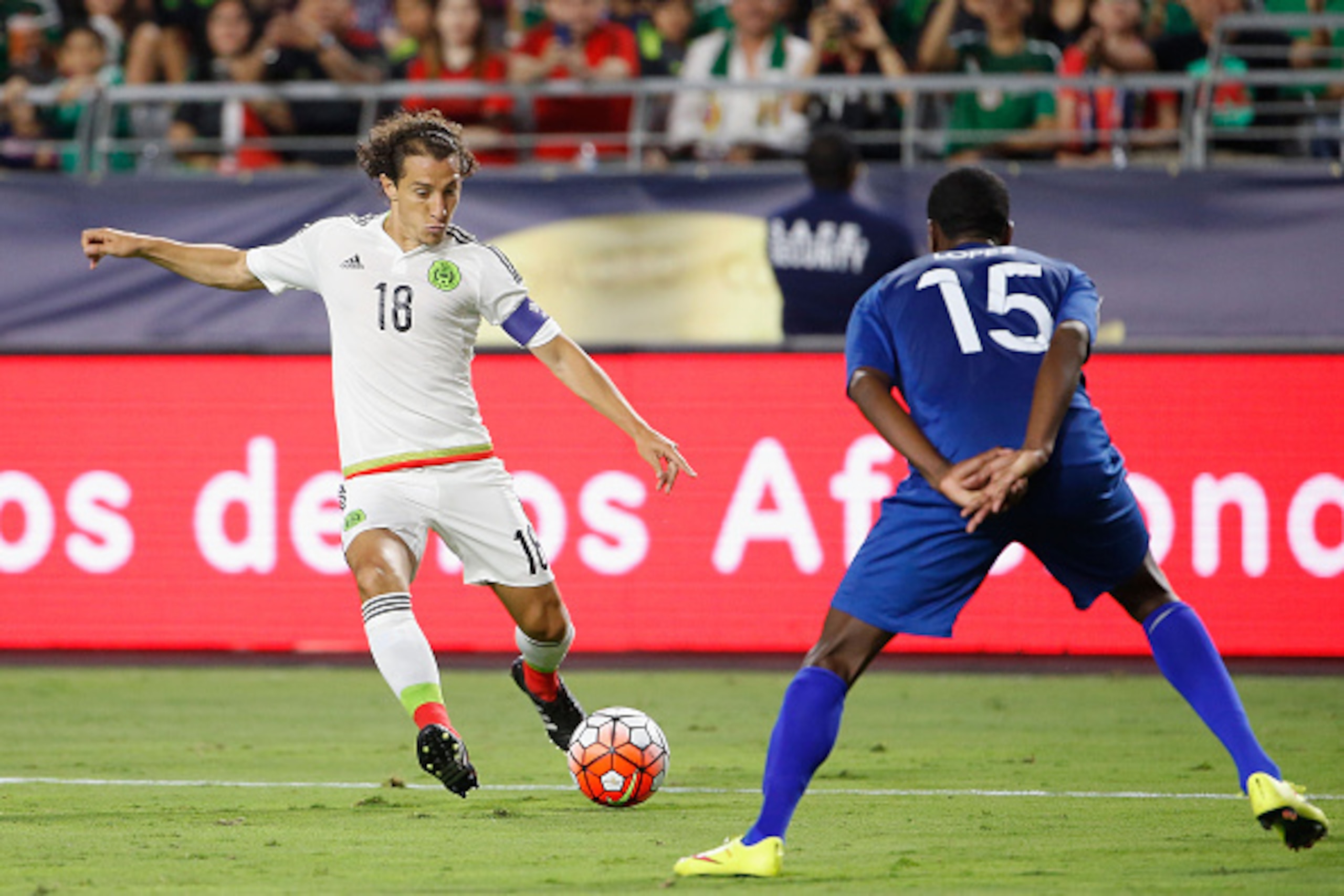 GLENDALE, AZ - JULY 12:  Andres Guardado #18 of Mexico kicks past Deniss Lopez #15 of Guatemala during the 2015 CONCACAF Gold Cup group C match at University of Phoenix Stadium on July 12, 2015 in Glendale, Arizona.  Guatemala and Mexico finished in a 0-0
