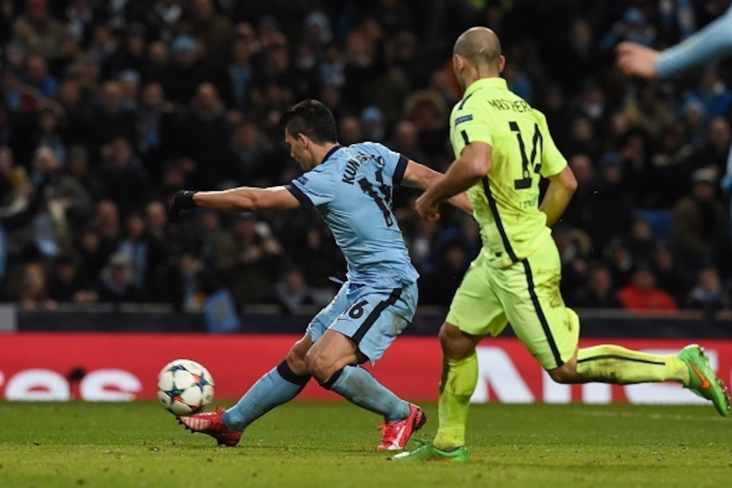 Manchester City's Argentinian striker Sergio Aguero (L) shoots to score his team's first goal during the UEFA Champions League round of 16 first leg football match between Manchester City and Barcelona at the Etihad Stadium in Manchester, northwest Englan