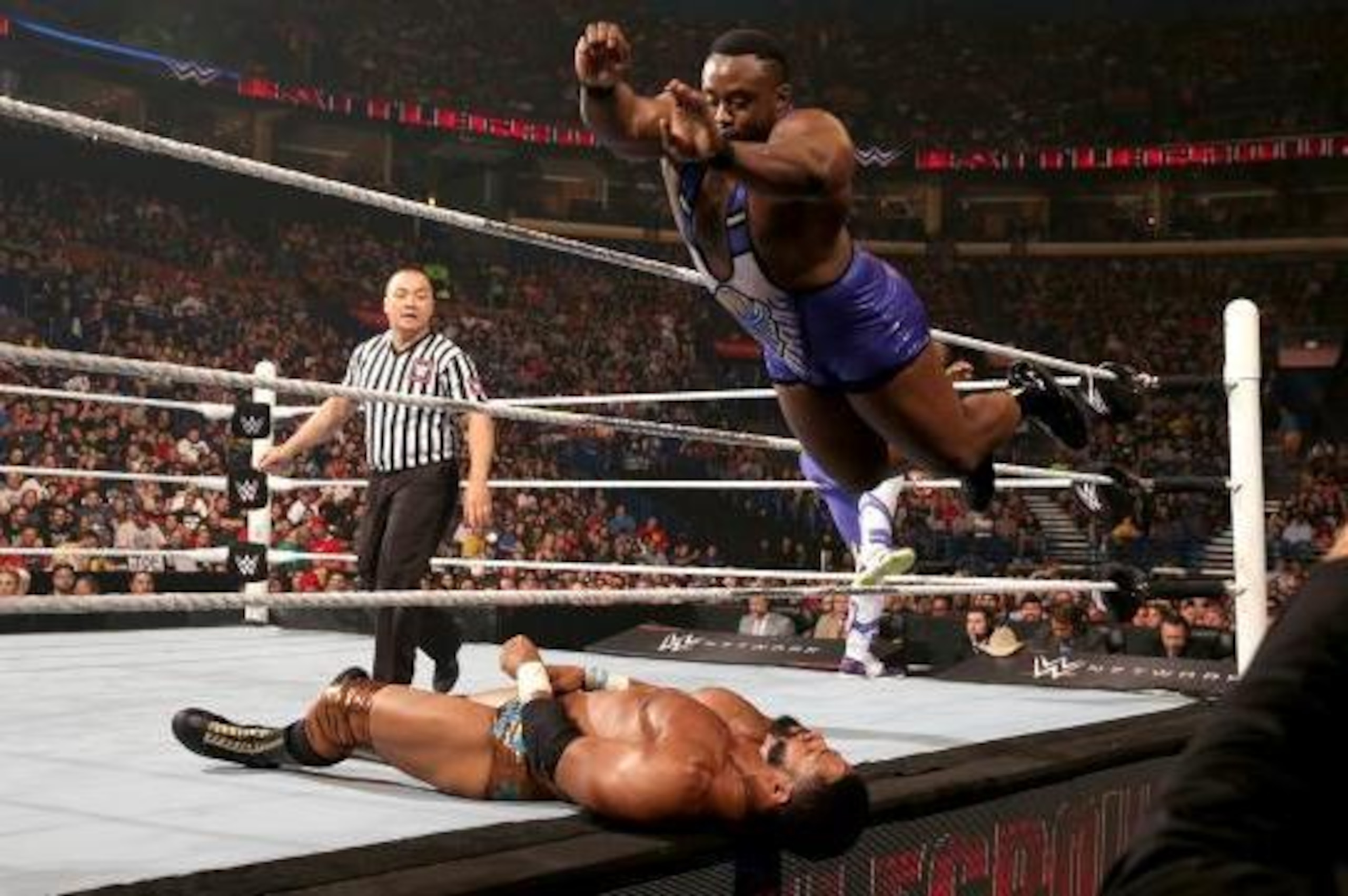 Big E hits a splash on the ring apron.