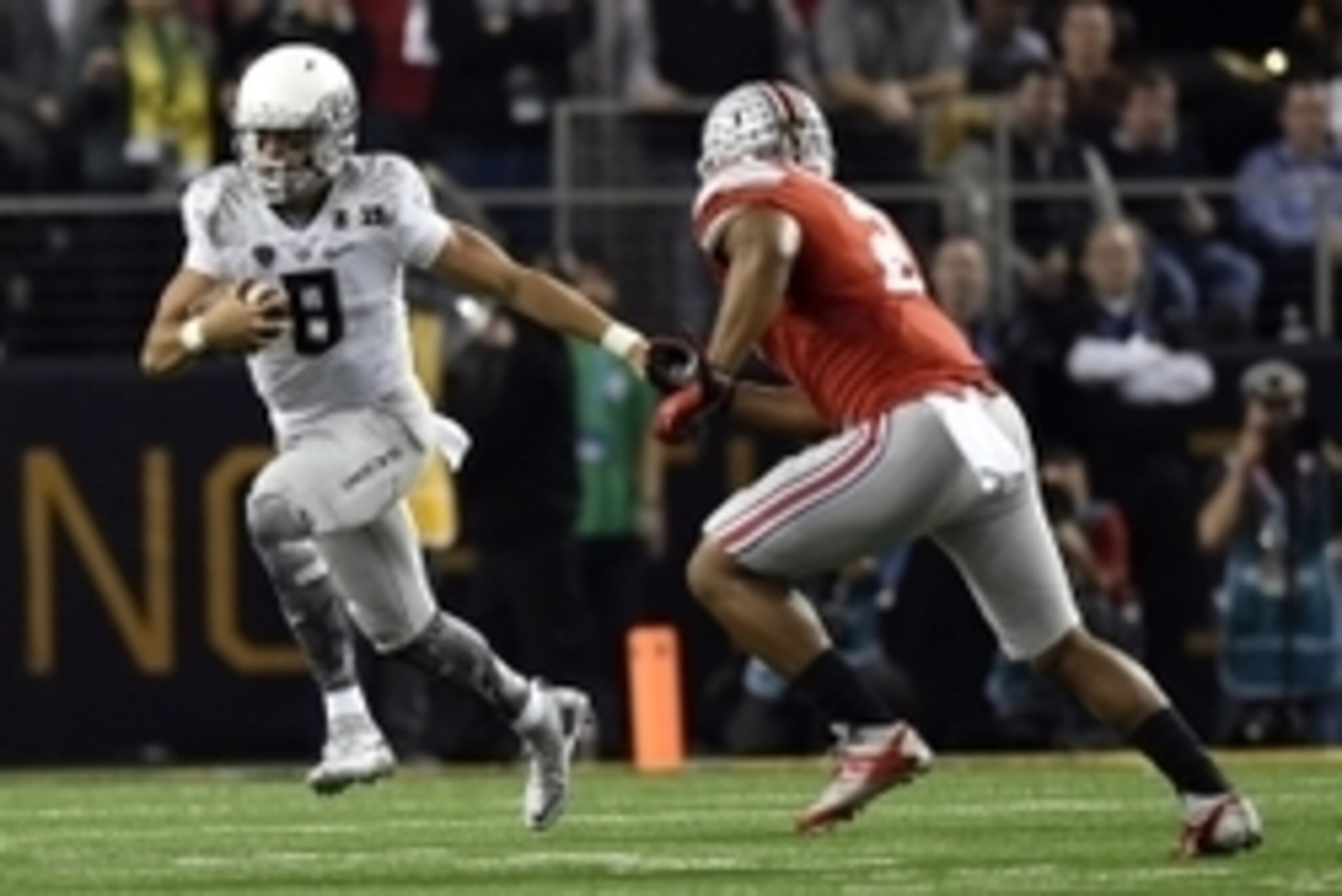 Jan 12, 2015; Arlington, TX, USA; Oregon Ducks quarterback Marcus Mariota (8) runs the ball against  Ohio State Buckeyes linebacker Raekwon McMillan (2) during the second quarter in the 2015 CFP National Championship Game at AT&T Stadium. Mandatory Credit