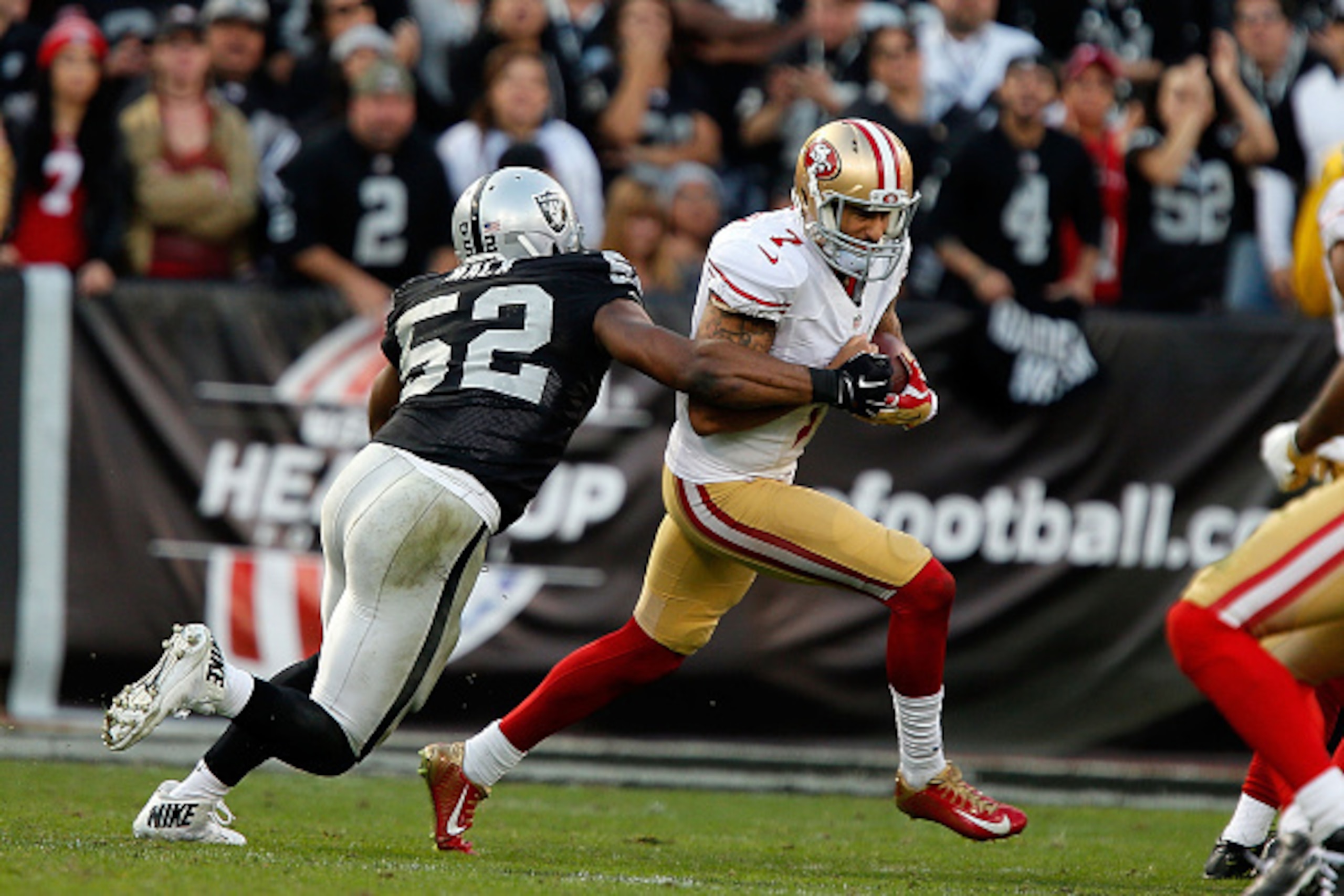 OAKLAND, CA - DECEMBER 07:  Colin Kaepernick #7 of the San Francisco 49ers flees pressure from Khalil Mack #52 of the Oakland Raiders in the fourth quarter at O.co Coliseum on December 7, 2014 in Oakland, California.  (Photo by Brian Bahr/Getty Images)