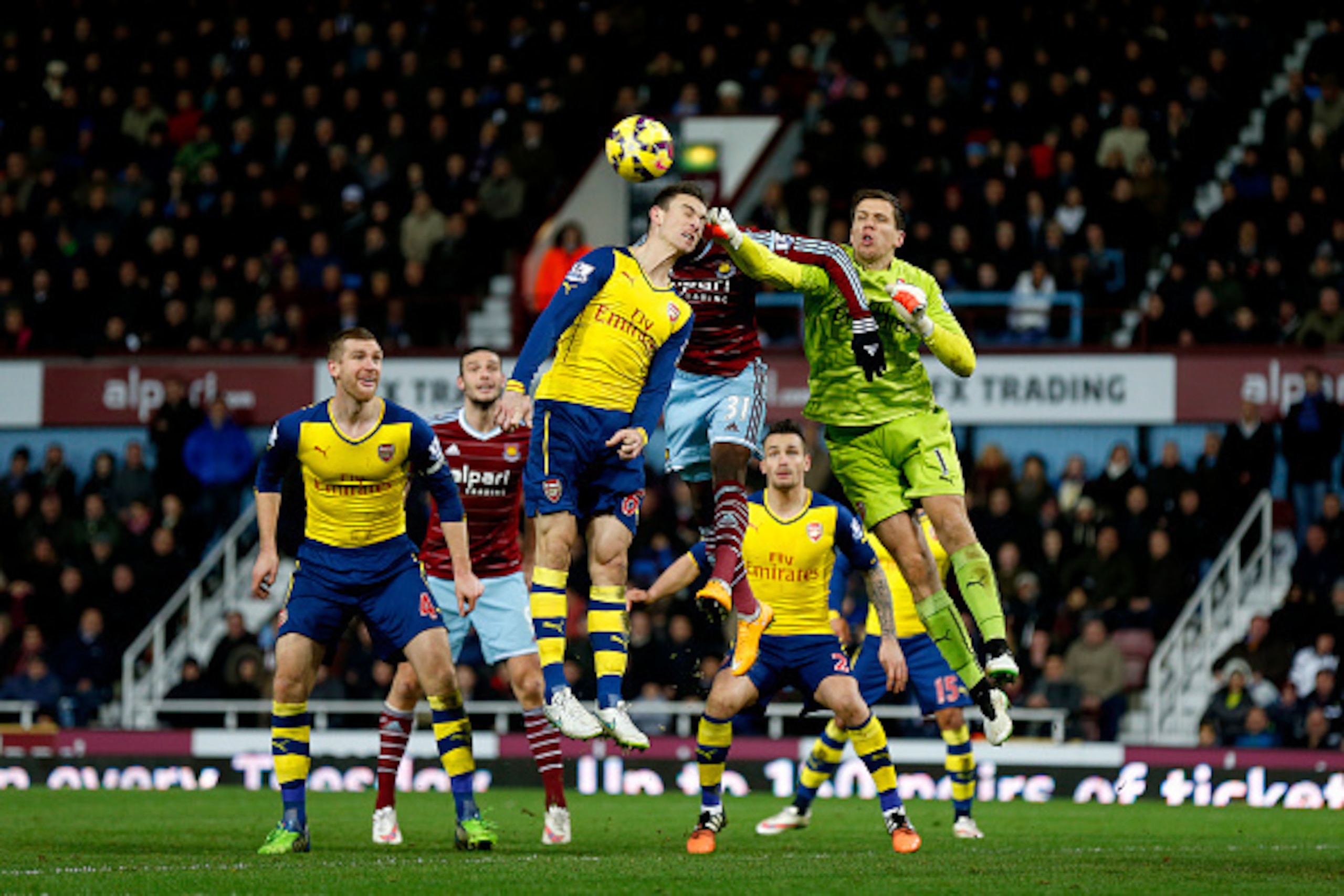 LONDON, ENGLAND - DECEMBER 28: Wojciech Szczesny of Arsenal punches the ball clear from Enner Valencia of West Ham during the Barclays Premier League match between West Ham United and Arsenal at Boleyn Ground on December 28, 2014 in London, England. (Ph LONDON, ENGLAND - DECEMBER 28: Wojciech Szczesny of Arsenal punches the ball clear from Enner Valencia of West Ham during the Barclays Premier League match between West Ham United and Arsenal at Boleyn Ground on December 28, 2014 in London, England. (Ph