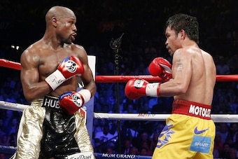 Floyd Mayweather Jr. exchange punches with Manny Pacquiao during their welterweight unification championship bout, May 2, 2015 at MGM Grand Garden Arena in Las Vegas, Nevada.  Mayweather defeated Pacquiao by unanimous decision.  AFP PHOTO / JOHN GURZINKSI