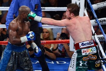 LAS VEGAS, NV - SEPTEMBER 14:  (R-L) Canelo Alvarez throws a left at Floyd Mayweather Jr. during their WBC/WBA 154-pound title fight at the MGM Grand Garden Arena on September 14, 2013 in Las Vegas, Nevada.  (Photo by Ethan Miller/Getty Images)