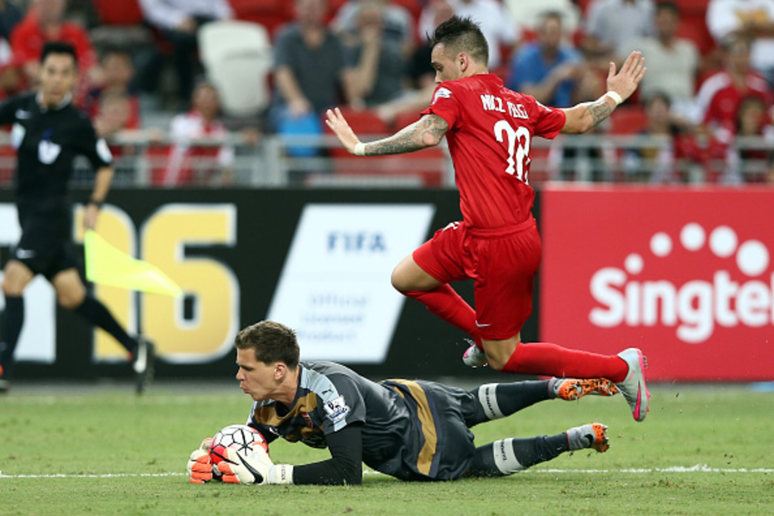 SINGAPORE - JULY 15: Wojciech Szczesny of Arsenal clashes with Nicholas Velez of Singapore during the Barclays Asia Trophy match between Arsenal and Singapore Select XI at National Stadium on July 15, 2015 in Singapore.  (Photo by Stanley Chou/Getty Image