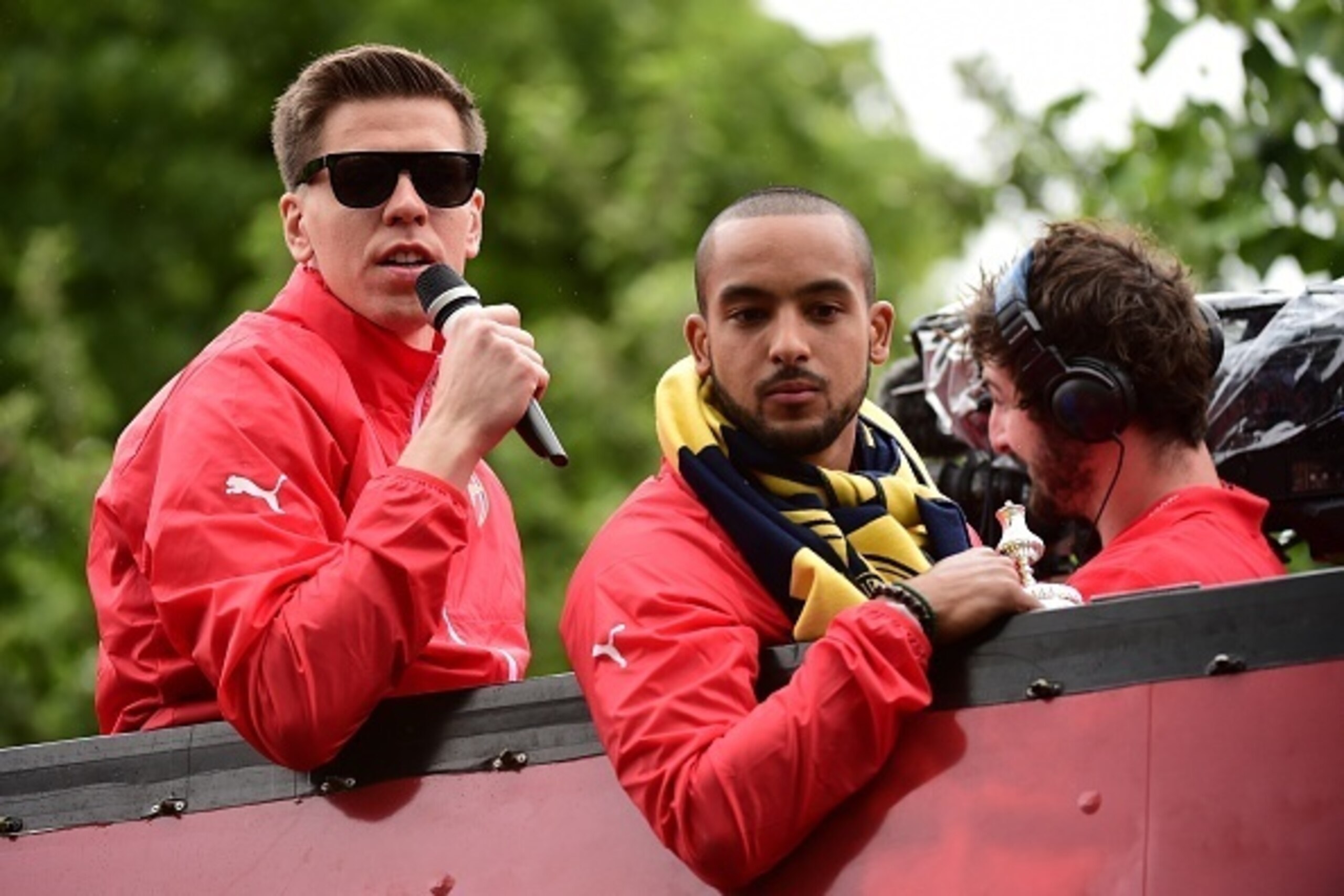 Arsenal's Polish goalkeeper Wojciech Szczesny (L) speaks to fans by Arsenal's English midfielder Theo Walcott from an open top bus during the Arsenal victory parade in London on May 31, 2015, following their win in the English FA Cup final football match 