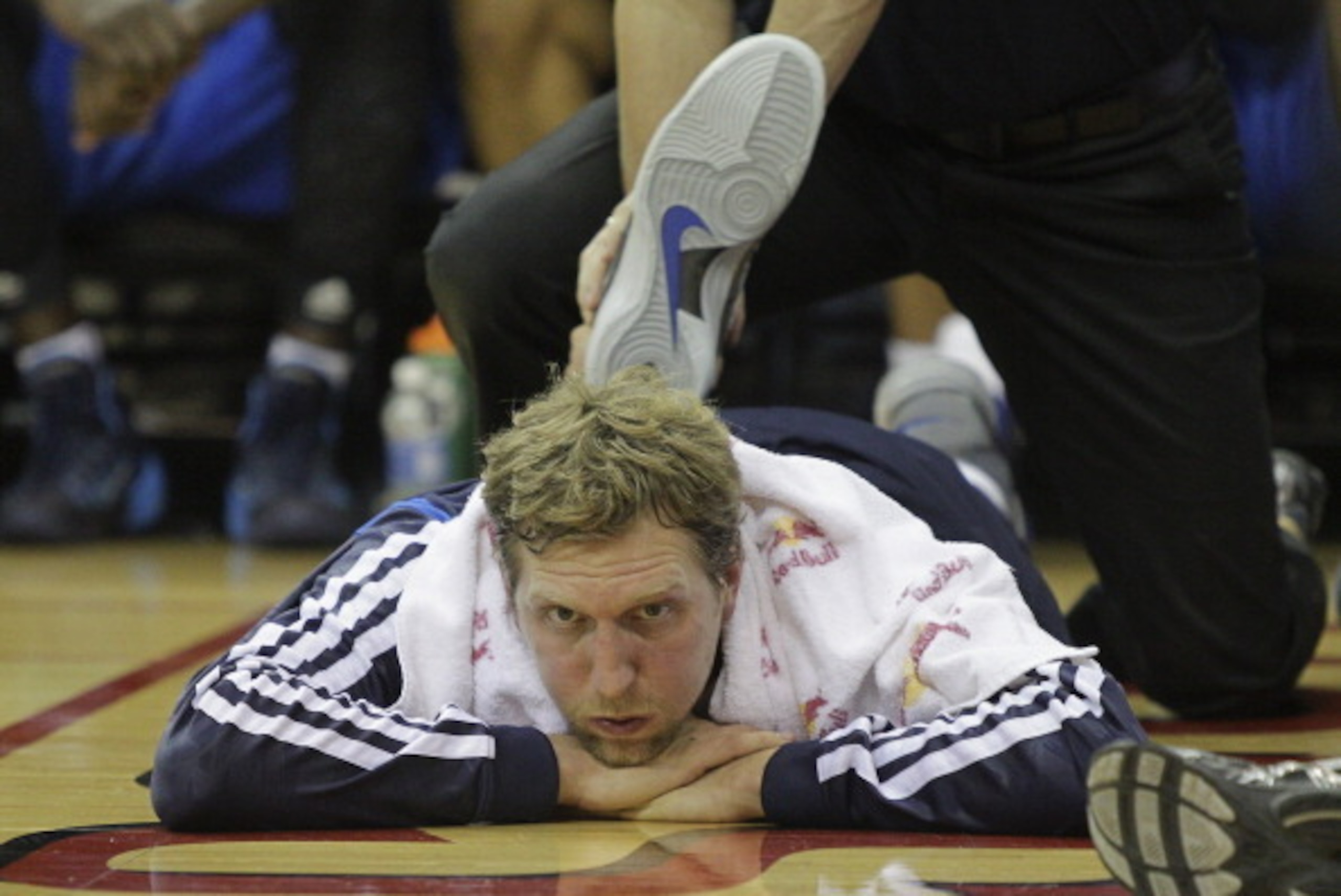 HOUSTON, TX - NOVEMBER 01:  Dirk Nowitzki #41 of the Dallas Mavericks receives some treatment  to his leg on the sideline after fouling out against the Houston Rockets at Toyota Center on November 1, 2013 in Houston, Texas. NOTE TO USER: User expressly ac