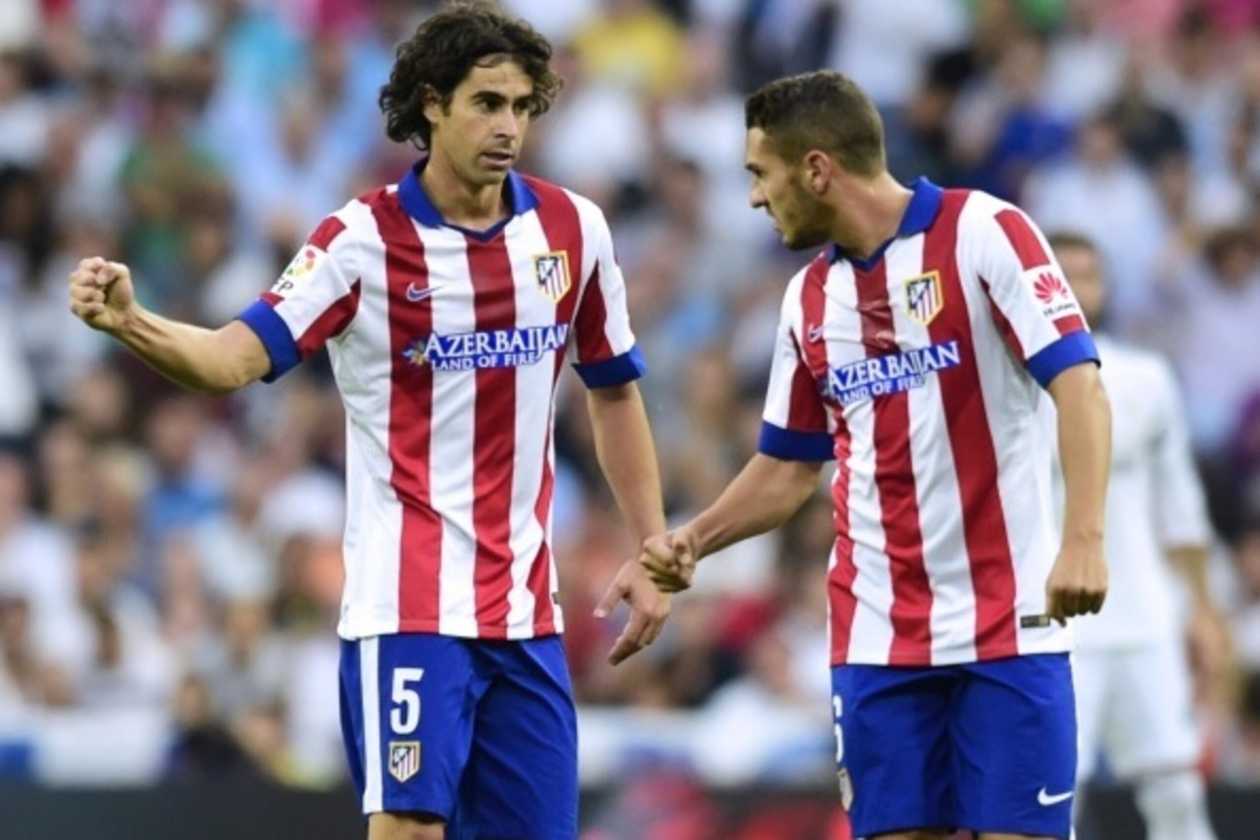 Atletico Madrid's Portuguese midfielder Tiago (L) celebrates with Atletico Madrid's midfielder Koke after scoring during the Spanish league football match Real Madrid CF vs Club Atletico de Madrid at the Santiago Bernabeu stadium in Madrid on September 13