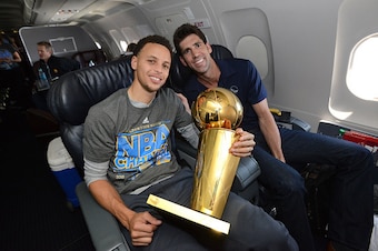 OAKLAND, CA - JUNE 17:  Stephen Curry #30 and Bob Myers of the Golden State Warriors holds the NBA trophy on the plane as the team travels home from Cleveland after winning the 2015 NBA Finals on June 17, 2015 in Oakland, California. NOTE TO USER: User ex