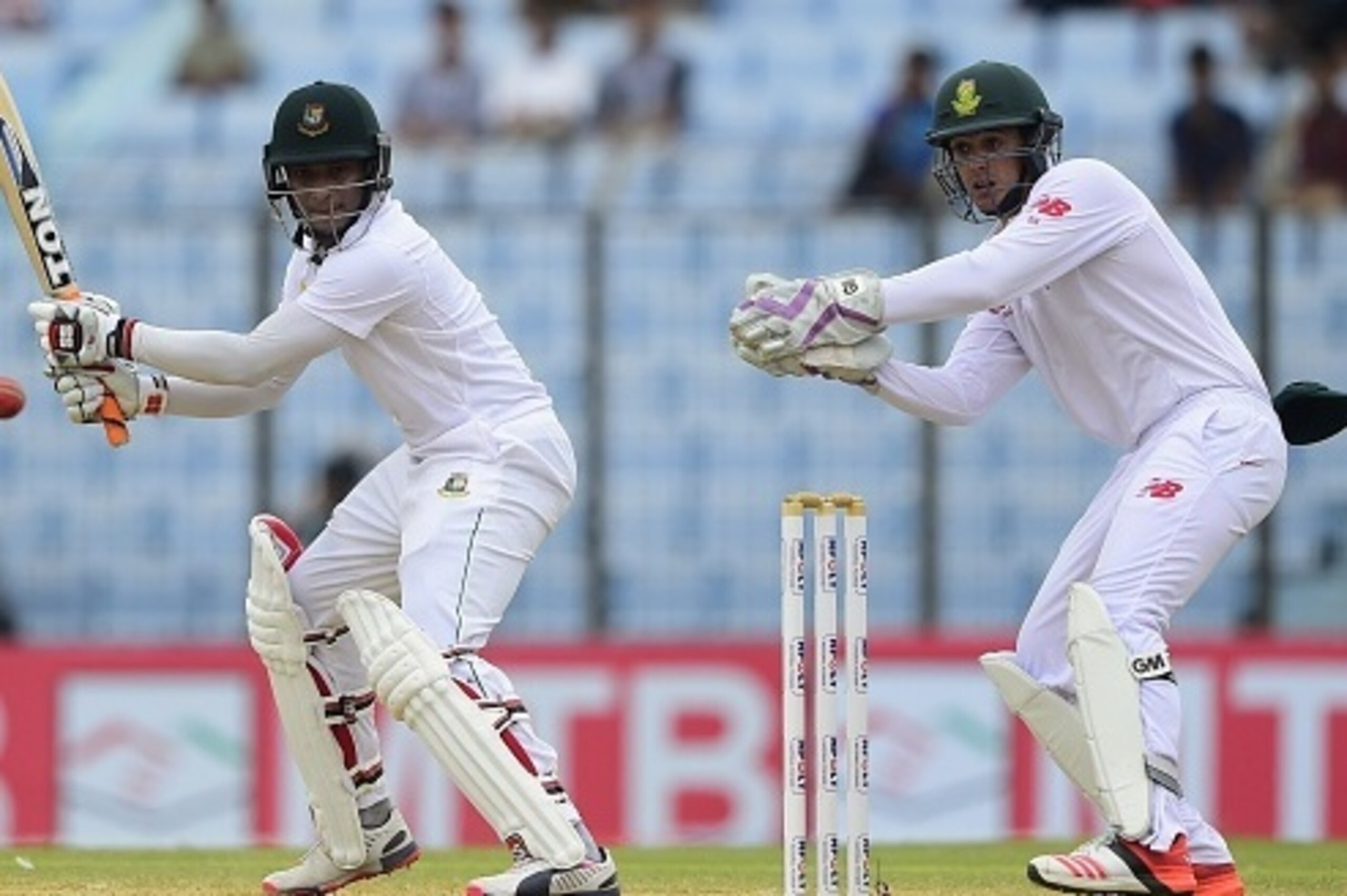 Bangladesh cricketer Shakib Al Hasan (L) plays a shot as the South Africa wicketkeeper Quinton de Kock (R) looks on during the third day of the first cricket Test match between Bangladesh and South Africa at the Zahur Ahmed Chowdhury Stadium in Chittagong