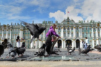 SAINT PETERSBURG, RUSSIA - JULY 20: A young girl feeds the pigeons in Palace Square during a media tour of Russia 2018 FIFA World Cup venues on July 20, 2015 in Saint Petersburg, Russia.  (Photo by Laurence Griffiths/Getty Images)
