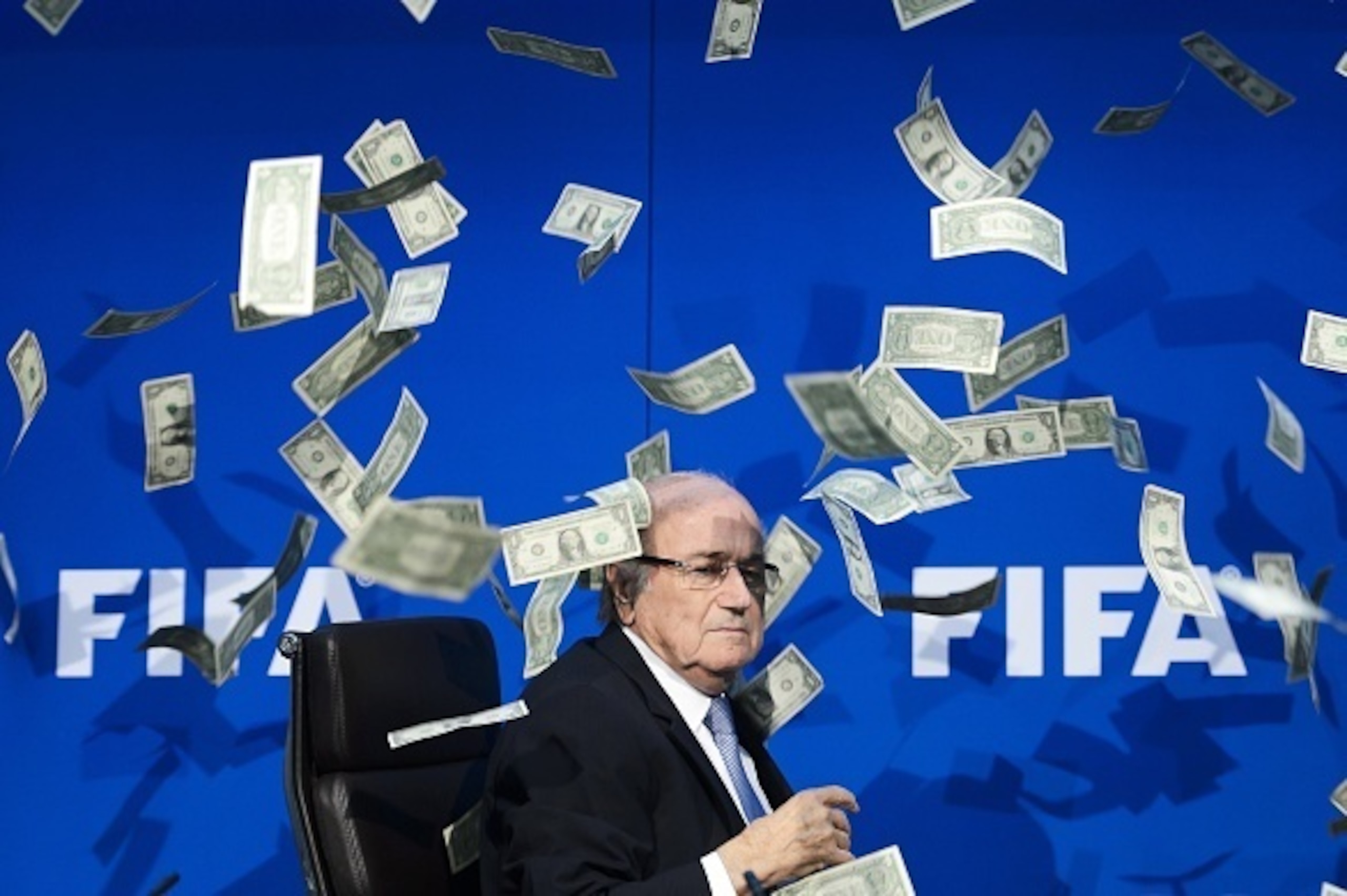 FIFA president Sepp Blatter looks on as fake dollar notes fly around him, thrown by a British comedian during a press conference at the FIFA world-body headquarter's on July 20, 2015 in Zurich. The 79-year-old Swiss official looked shaken as the notes thr FIFA president Sepp Blatter looks on as fake dollar notes fly around him, thrown by a British comedian during a press conference at the FIFA world-body headquarter's on July 20, 2015 in Zurich. The 79-year-old Swiss official looked shaken as the notes thr