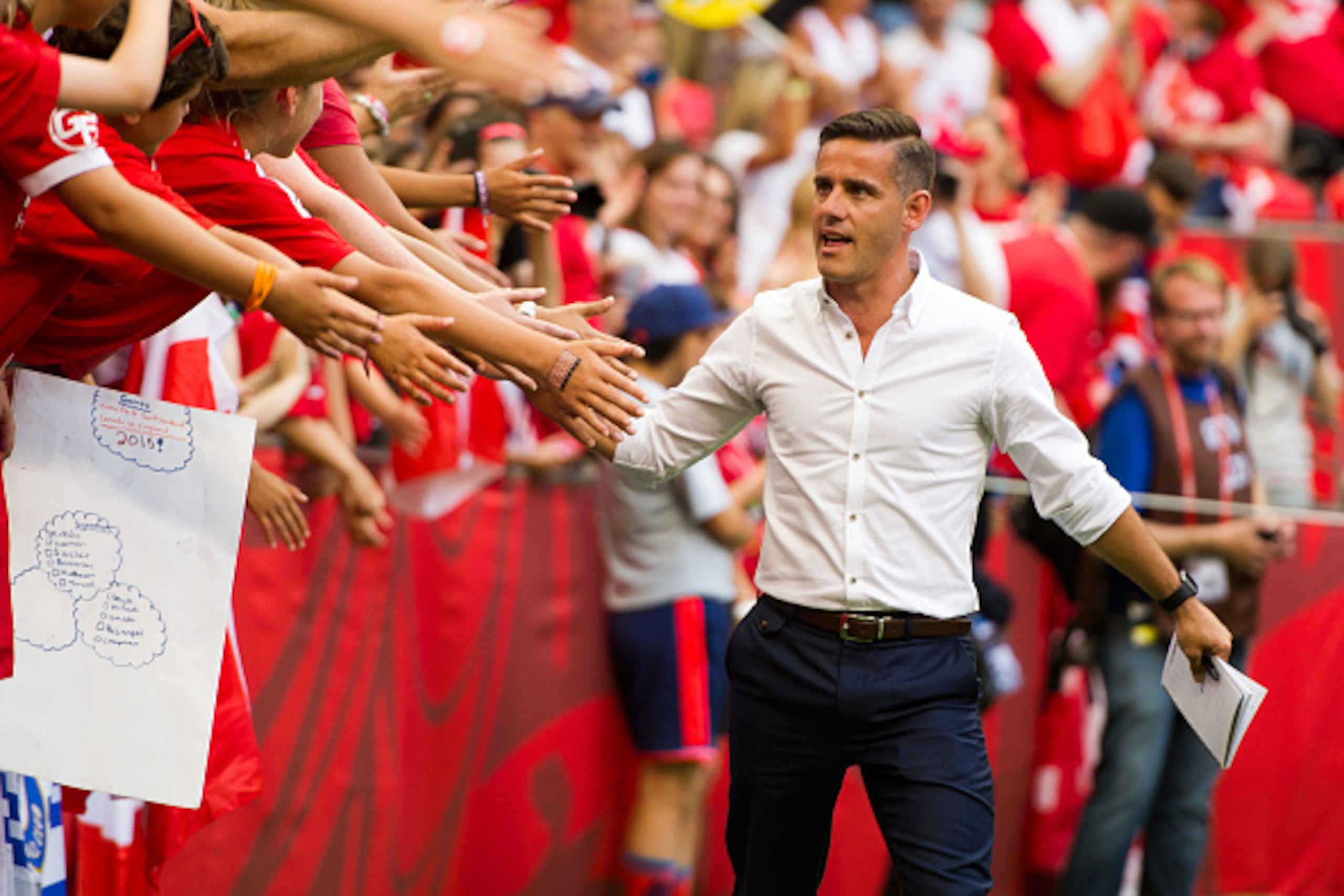 VANCOUVER, BC - JUNE 27: John Herdman Head Coach of Canada high fives fans prior to the start of the FIFA Women's World Cup Canada 2015 Quarter Final match between the England and Canada June, 27, 2015 at BC Place Stadium in Vancouver, British Columbia, C
