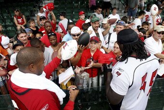 LAKE BUENA VISTA, FL - JULY 28:   Linebacker Shelton Quarles #53, L, and offensive lineman Davin Joseph #75 of the Tampa Bay Buccaneers sign autographs for fans after practice during training camp at Disney's Wide World of Sports on July 28, 2006 in Lake 