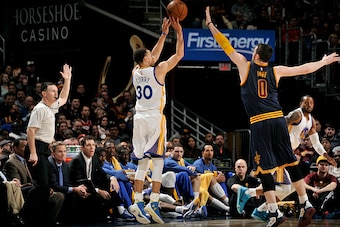 CLEVELAND, OH - FEBRUARY 26: Stephen Curry #30 of the Golden State Warriors shoots against Kevin Love #0 of the Cleveland Cavaliers at The Quicken Loans Arena on February 26, 2015 in Cleveland, Ohio. NOTE TO USER: User expressly acknowledges and agrees th