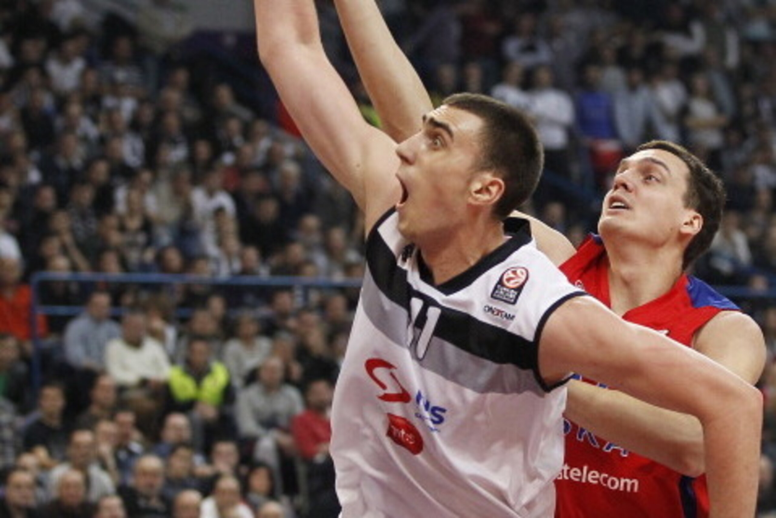 BELGRADE, SERBIA - JANUARY 17: Nikola Milutinov (L) of Partizan Belgrade jump for the ball with Sasha Kaun (R) of CSKA Moscow during the 2013-2014 Turkish Airlines Euroleague Top 16 game between Partizan Belgrade and CSKA Moscow at Kombank Arena on Januar