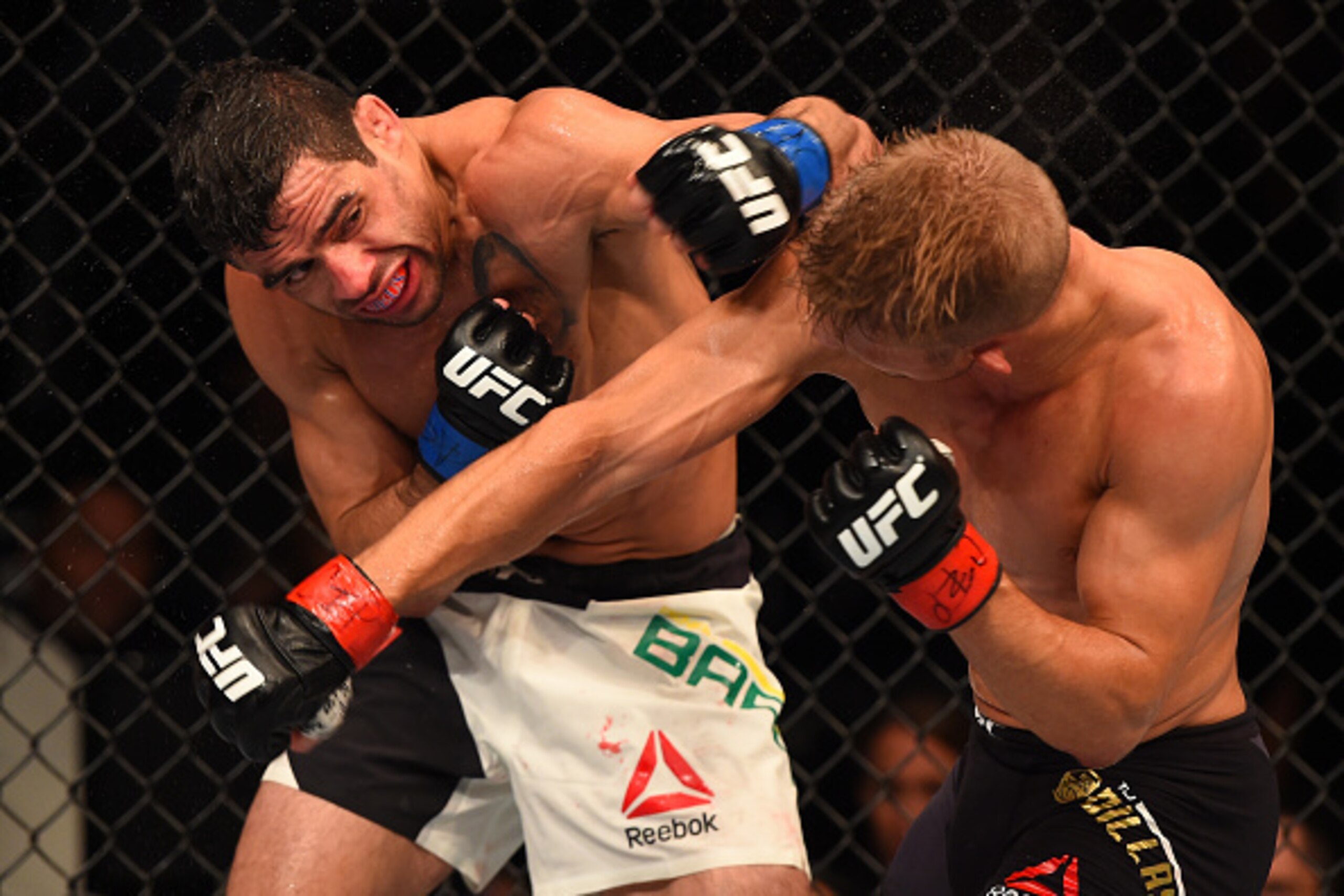 CHICAGO, IL - JULY 25:   (L-R) Renan Barao of Brazil and TJ Dillashaw trade punches in their UFC bantamweight championship bout during the UFC event at the United Center on July 25, 2015 in Chicago, Illinois. (Photo by Jeff Bottari/Zuffa LLC/Zuffa LLC via
