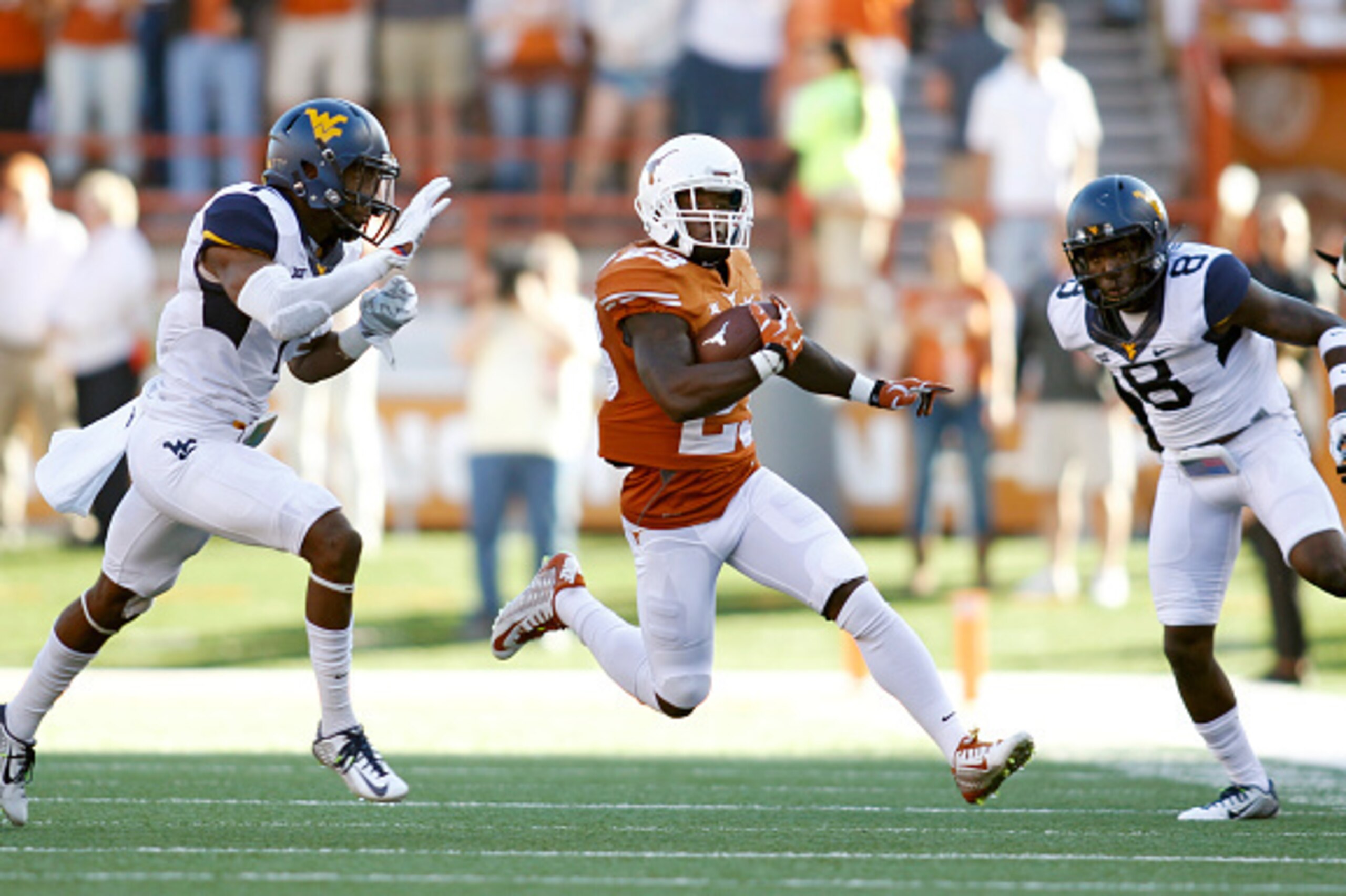 AUSTIN, TX - NOVEMBER 8: Wide receiver Daje Johnson #23 of the Texas Longhorns avoids a tackle by cornerback Daryl Worley #7 and safety Karl Joseph #8 of the West Virginia Mountaineers the NCAA Big 12 game between the Texas Longhorns and the West Virginia