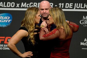 RIO DE JANEIRO, BRAZIL - MARCH 20:  UFC Women's Bantamweight Champion Ronda Rousey of the United States and Bethe Correia of Brazil face off as UFC President Dana White (C) stands in during the 189 World Media Tour Launch press conference at Maracanazinho