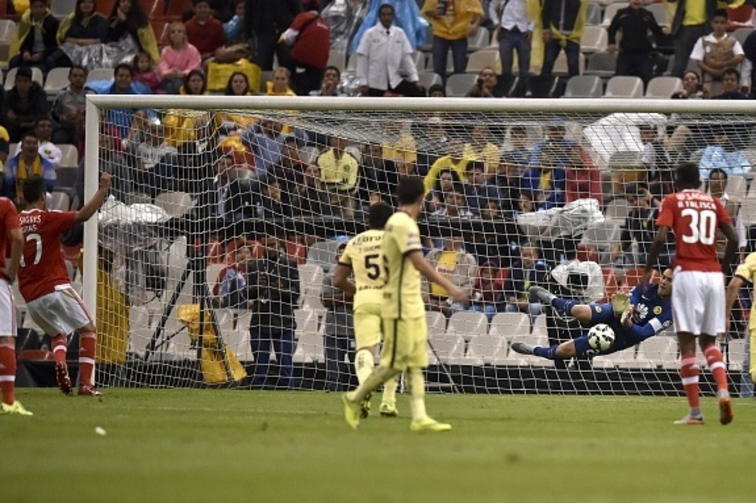 America's goalkeeper Moises Munoz stops the ball during a penalty by Benfica's forward Jonas (L) during their International Champions Cup tournament match at the Azteca stadium in Mexico City on July 28, 2015. AFP PHOTO/ Yuri CORTEZ        (Photo credit s