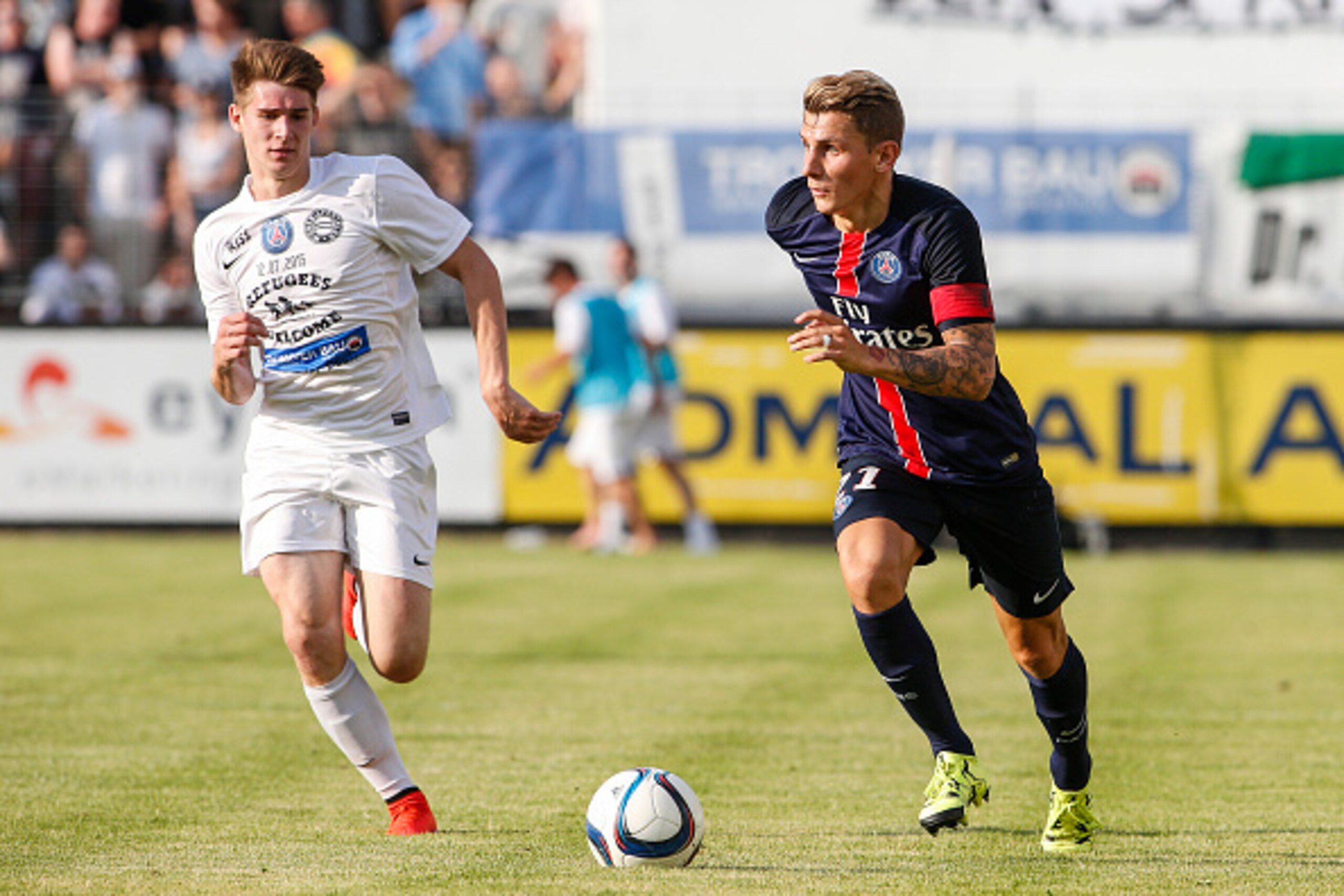 VIENNA, AUSTRIA - JULY 12:  Eric Auss of Wiener Sportklub (L) competes for the ball with Lucas Digne of Paris Saint-Germain during the Friendly Match between Wiener Sportklub and Paris Saint-Germain at Sportclub Platz on July 12, 2015 in Vienna, Austria. 