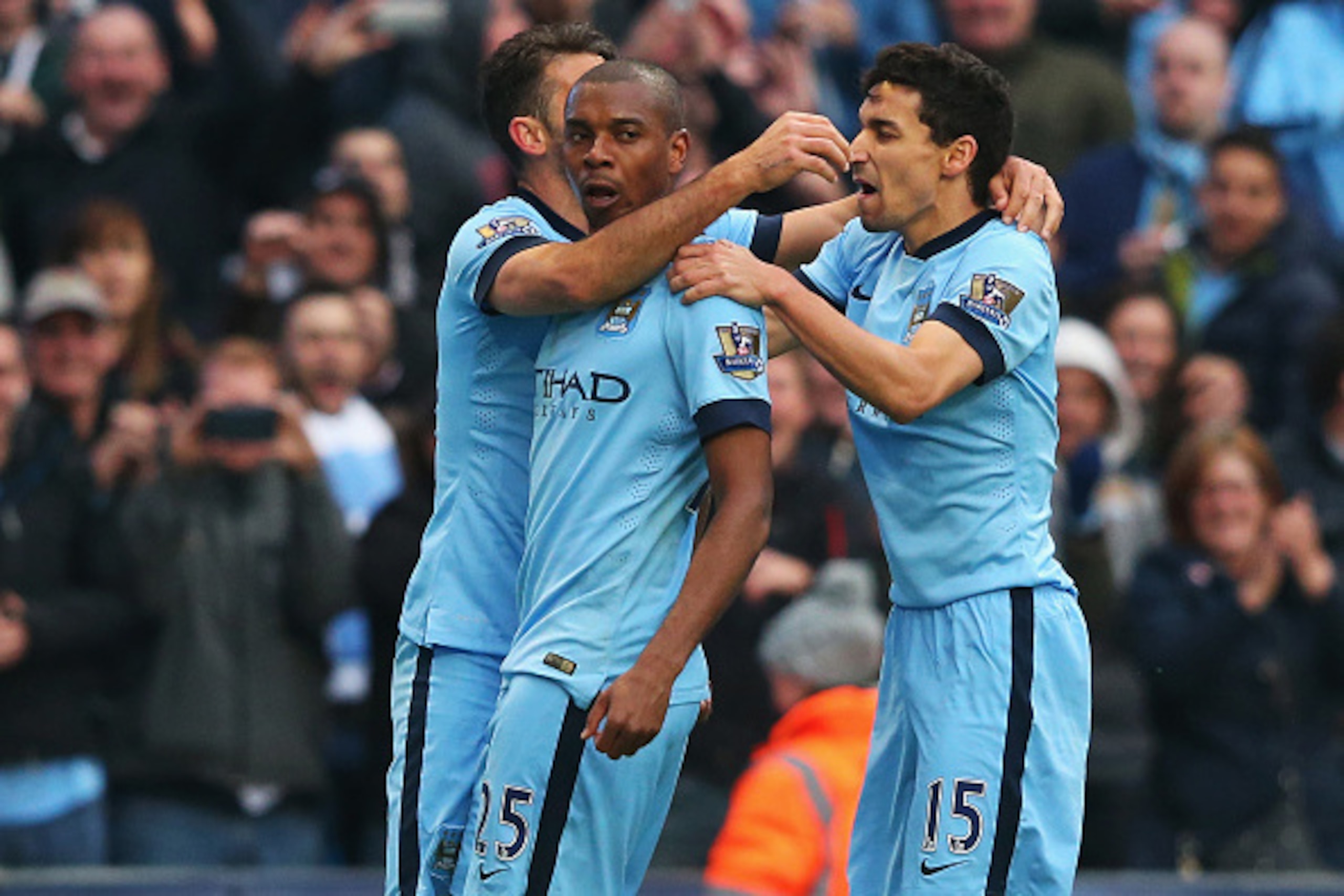 MANCHESTER, ENGLAND - APRIL 25:  Fernandinho of Manchester City celebrates his winning goal with Martin Demichelis (L) and Jesus Navas of Manchester City during the Barclays Premier League match between Manchester City and Aston Villa at Etihad Stadium on