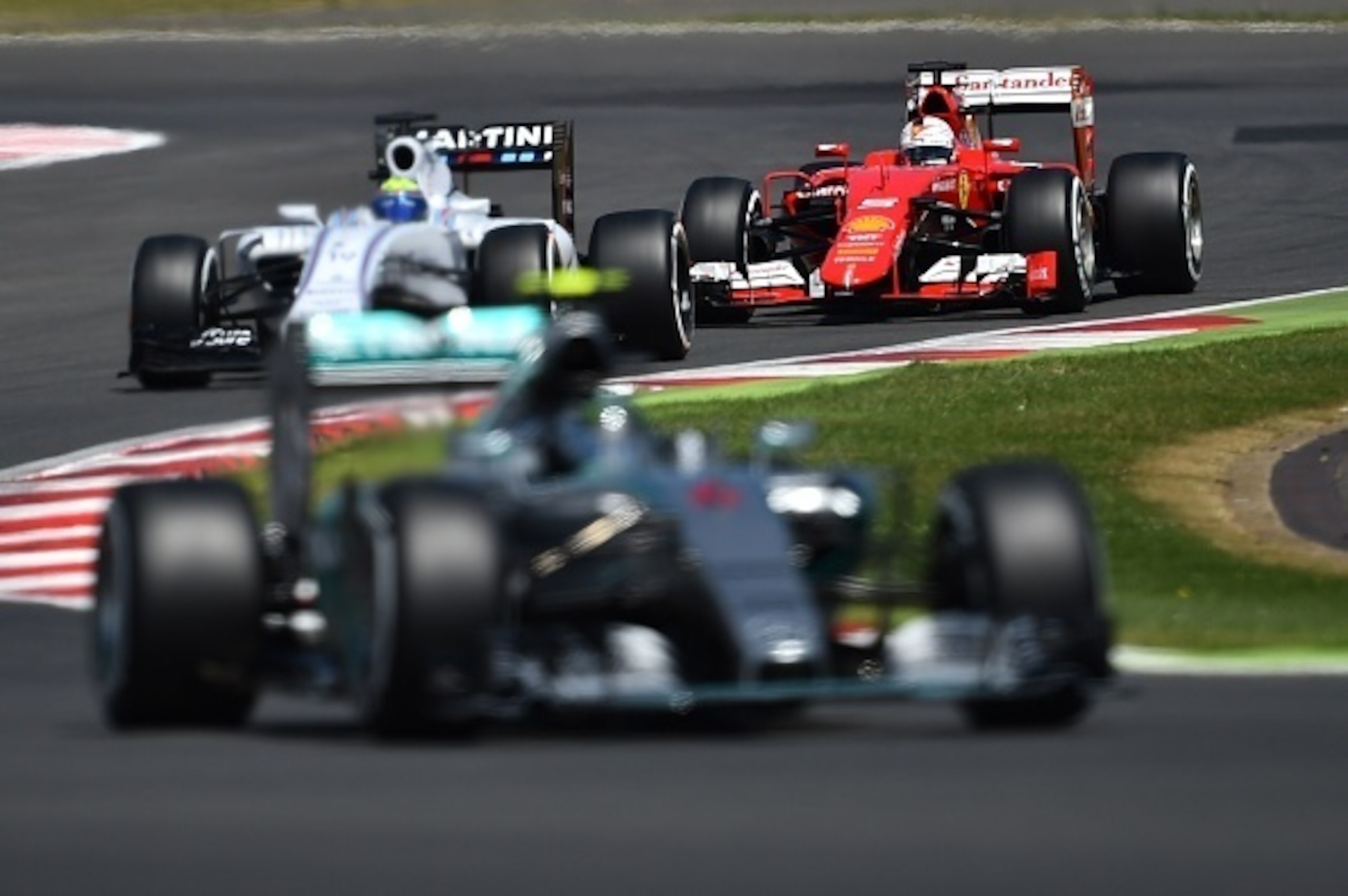 Mercedes AMG Petronas F1 Team's German driver Nico Rosberg (front), Williams Martini Racing's Brazilian driver Felipe Massa (C) and Ferrari's German driver Sebastian Vettel  drive during the qualifying session at the Silverstone circuit in Silverstone on 