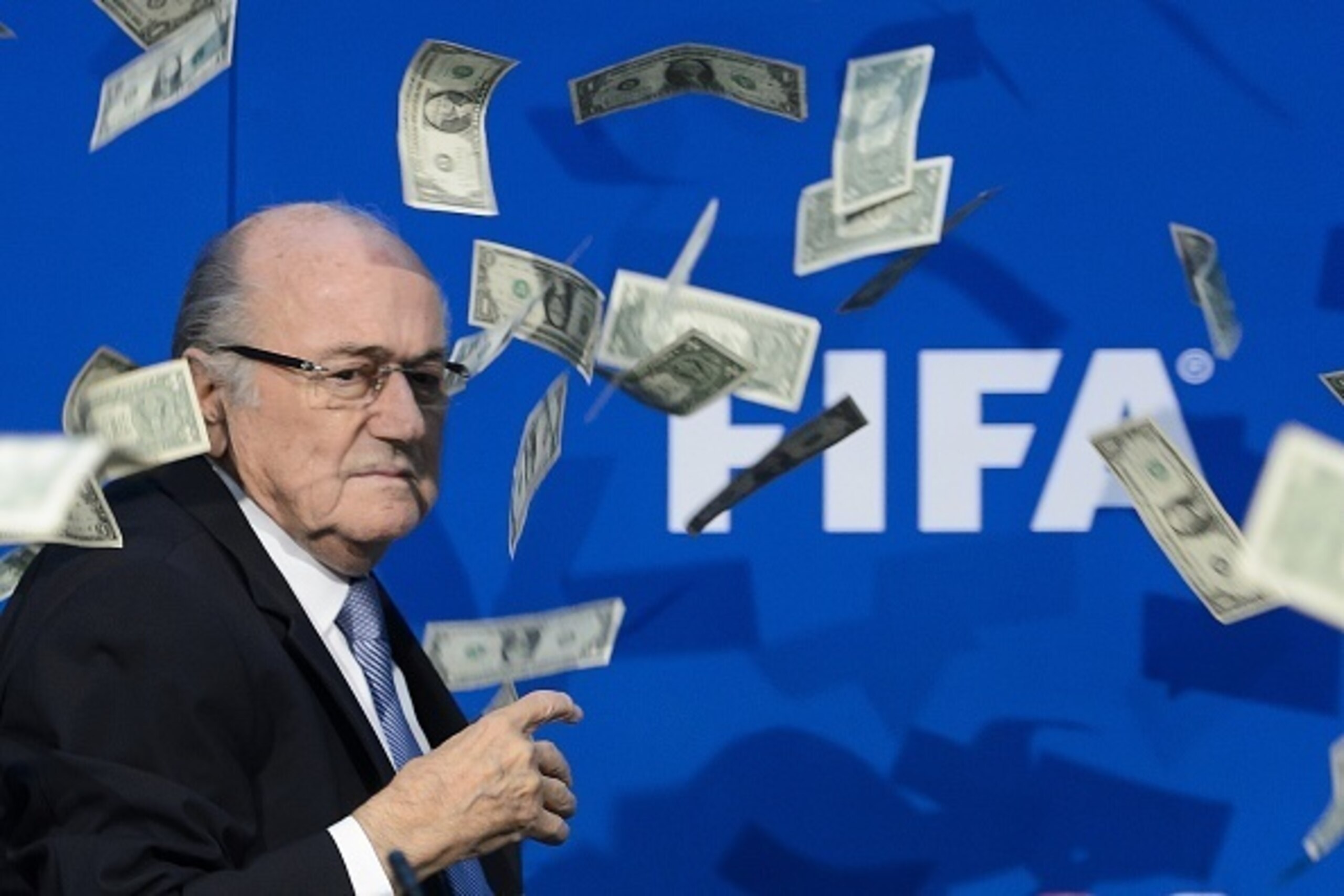 FIFA president Sepp Blatter looks on with fake dollars note flying around him thrown by a protester during a press conference at the football's world body headquarter's on July 20, 2015 in Zurich. FIFA said Monday that a special election will be held on F FIFA president Sepp Blatter looks on with fake dollars note flying around him thrown by a protester during a press conference at the football's world body headquarter's on July 20, 2015 in Zurich. FIFA said Monday that a special election will be held on F