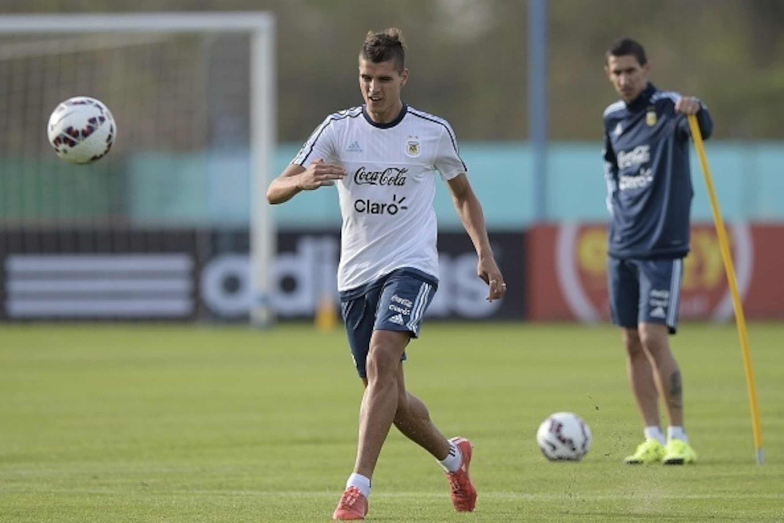 Argentina's national football team midfielder Erik Lamela (L) kicks the ball next to midfielder Angel Di Maria during a training session in Ezeiza, Buenos Aires on June 1, 2015 ahead of a friendly football match against Bolivia next June 6, in San Juan, a