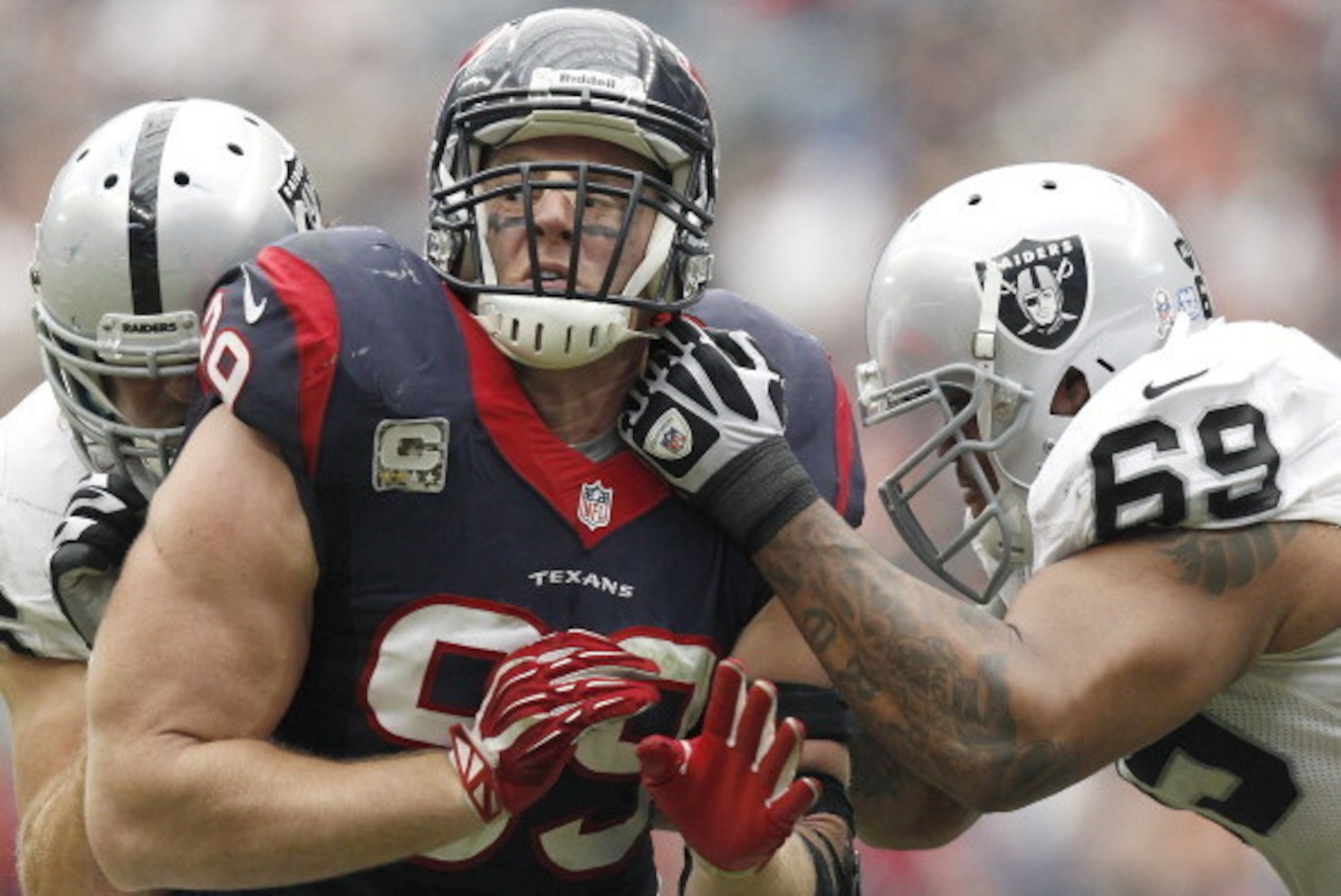HOUSTON, TX- NOVEMBER 17: J.J. Watt #99 of the Houston Texans rushes Khalif Barnes #69 of the Oakland Raiders on November 17, 2013 at Reliant Stadium in Houston, Texas. Raiders won 28 to 23.(Photo by Thomas B. Shea/Getty Images)
