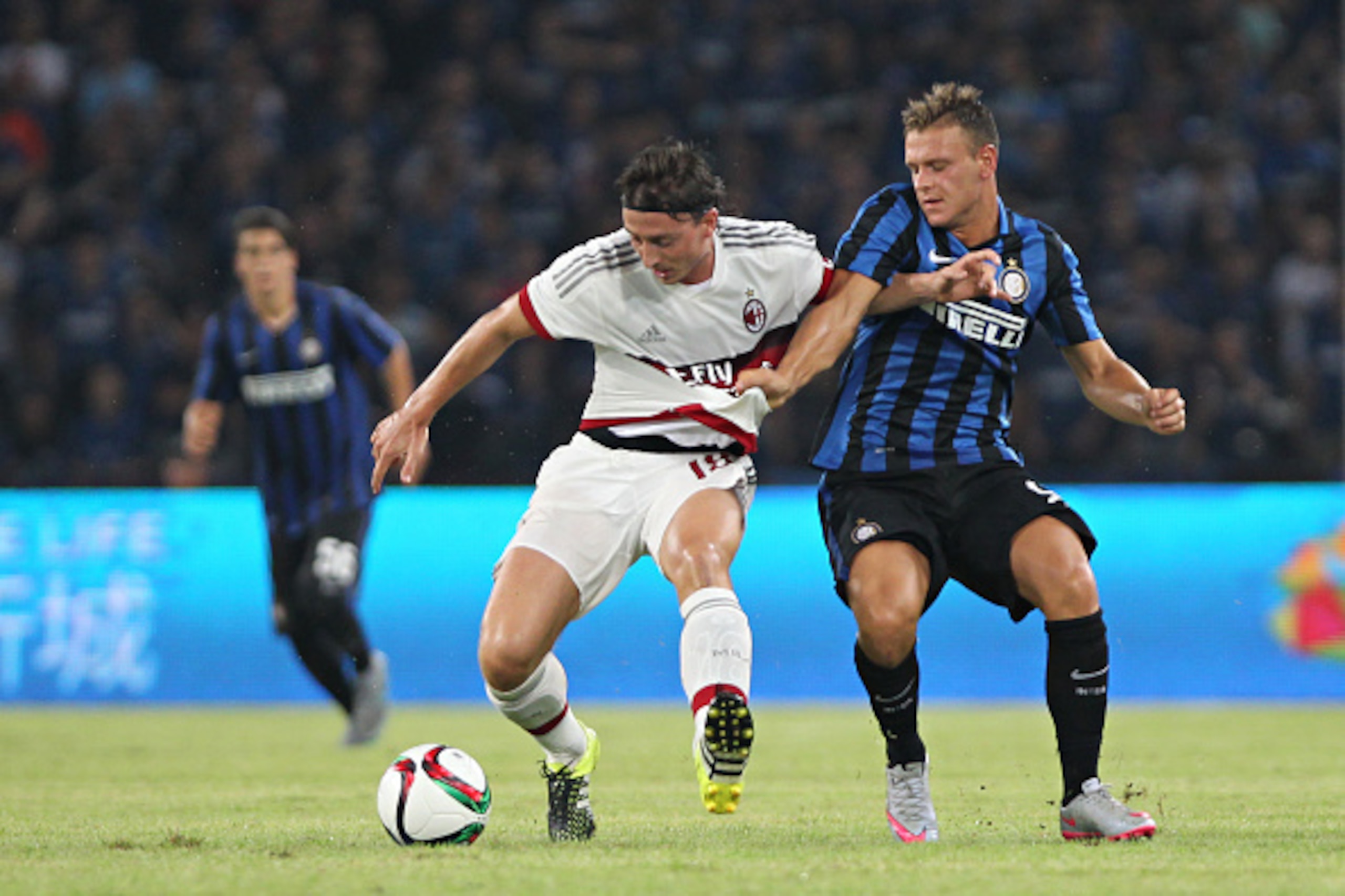 GUANGZHOU, CHINA - JULY 25: Montolivo Riccardo of AC Milan competes the ball with Dimarco Federico of FC Internazionale during the match of International Champions Cup China 2015 between AC Milan and FC Internazionale at Longgang Sport Center Stadium on J