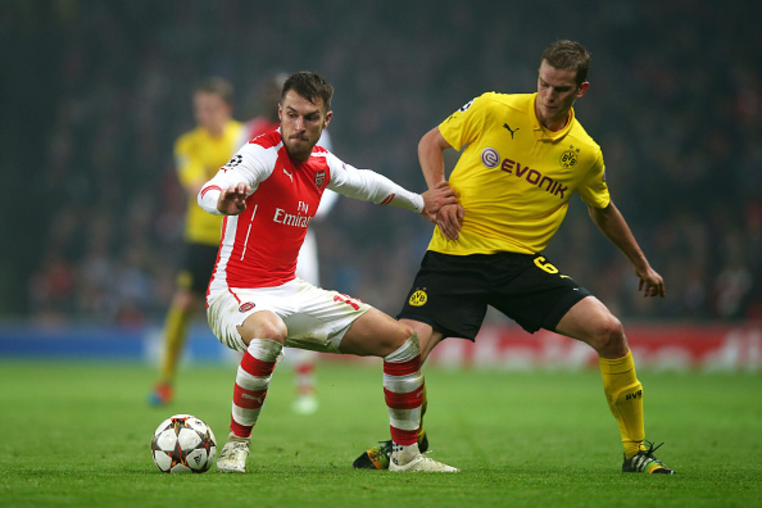 LONDON, ENGLAND - NOVEMBER 26:  Aaron Ramsey of Arsenal holds off the challenge from Sven Bender of Borussia Dortmund during the UEFA Champions League Group D match between Arsenal and Borussia Dortmund at the Emirates Stadium on November 26, 2014 in Lond