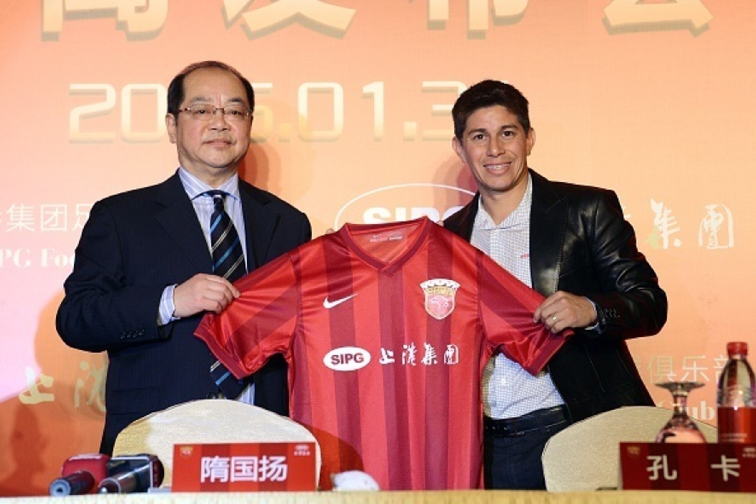 Chinese Super League football club Shanghai SIPG team manager Sui Guoyang (L) poses with Argentine star Dario Conca after he signed to play for the club in Shanghai on January 31, 2015.  Conca returns to China after only a year at Brazilian club Fluminens