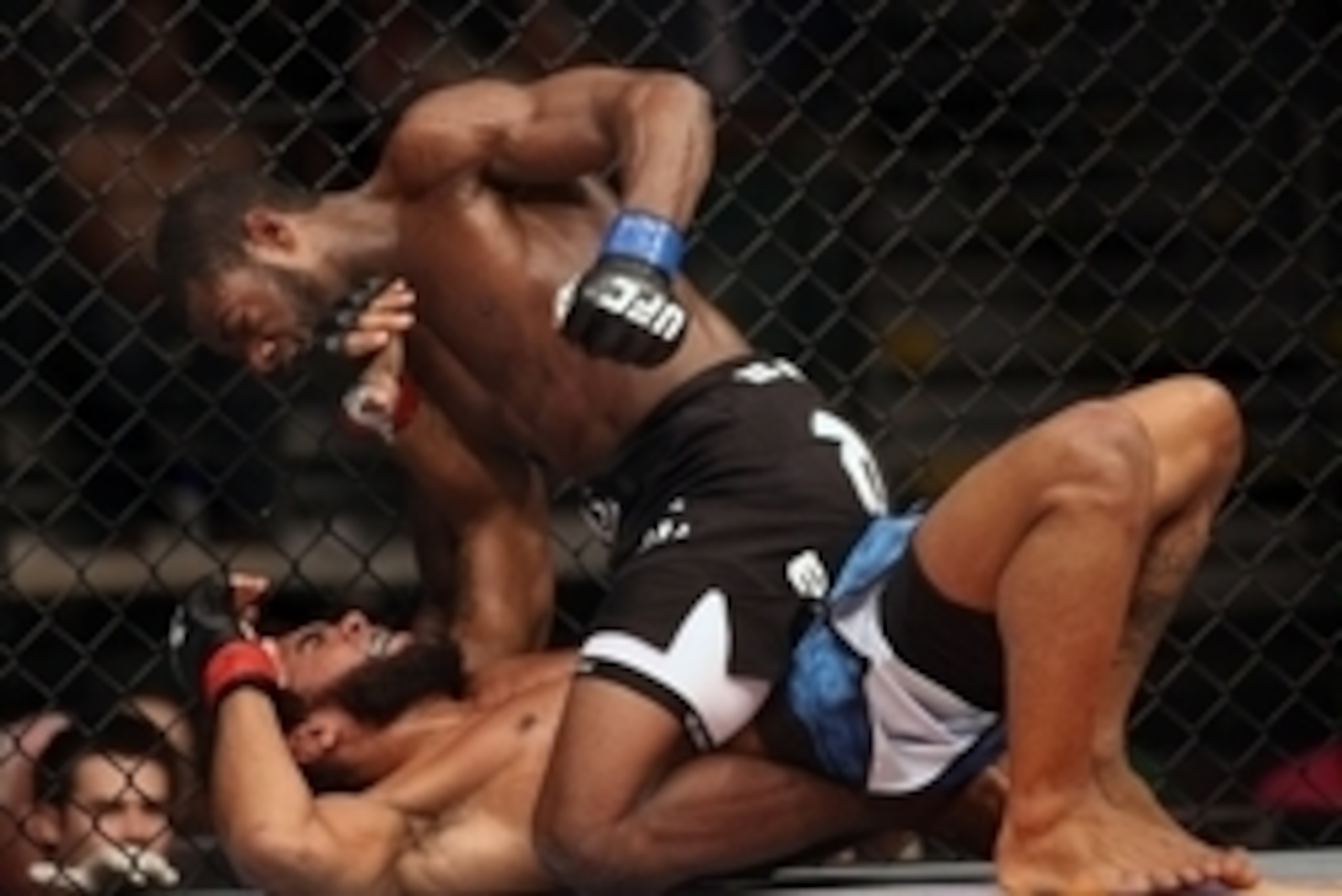 Jul 16, 2014; Atlantic City, NJ, USA; Aljamain Sterling pulls back for a punch while on top of a prone Hugo Viana (red gloves) during a bantamweight bout at Revel Casino. Mandatory Credit: Bill Streicher-USA TODAY Sports
