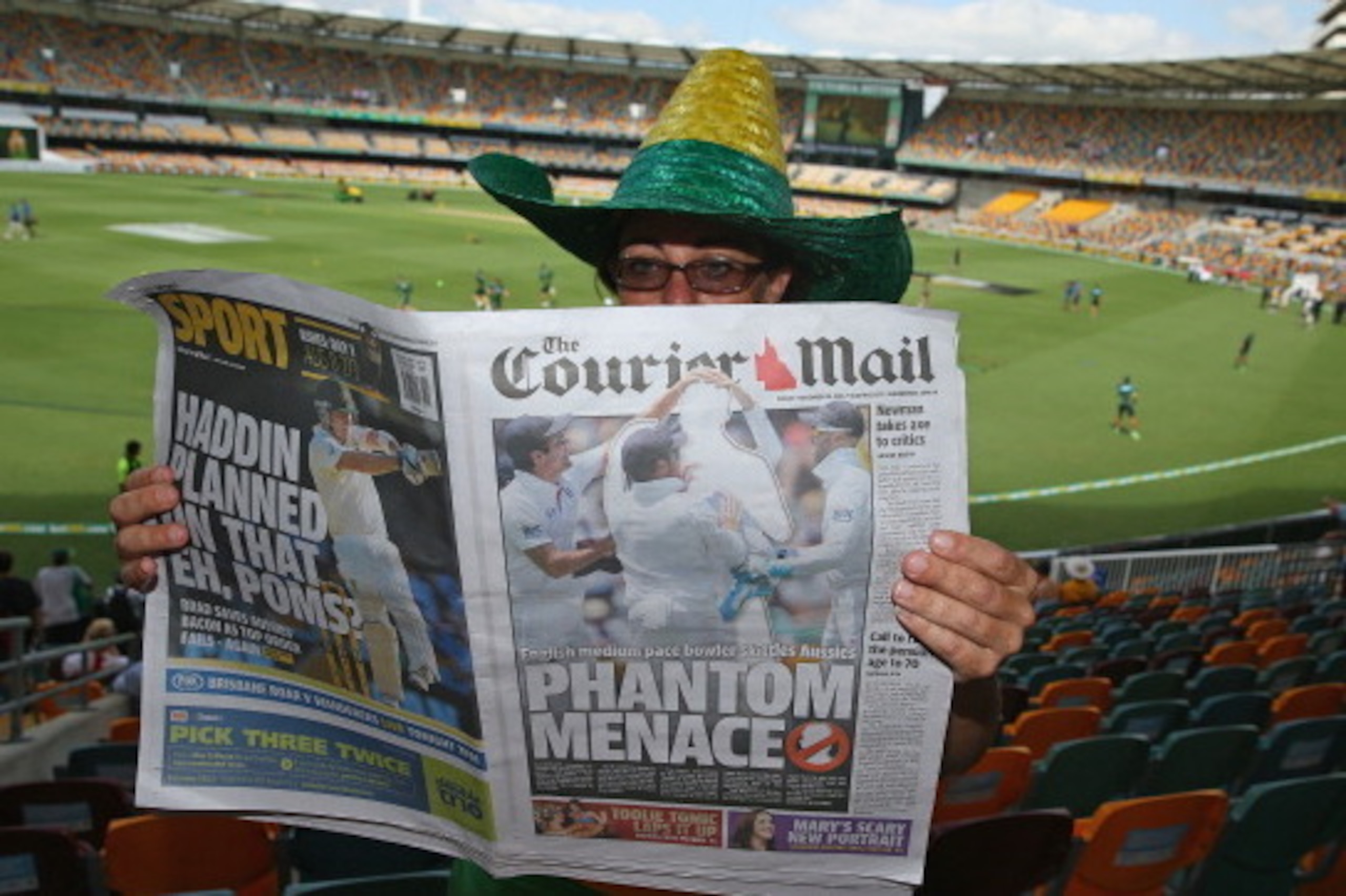 BRISBANE, AUSTRALIA - NOVEMBER 22:  An Australian supporter reads a copy of the Courier Mail newspaper day two of the First Ashes Test match between Australia and England at The Gabba on November 22, 2013 in Brisbane, Australia. The Queensland Courier Mai