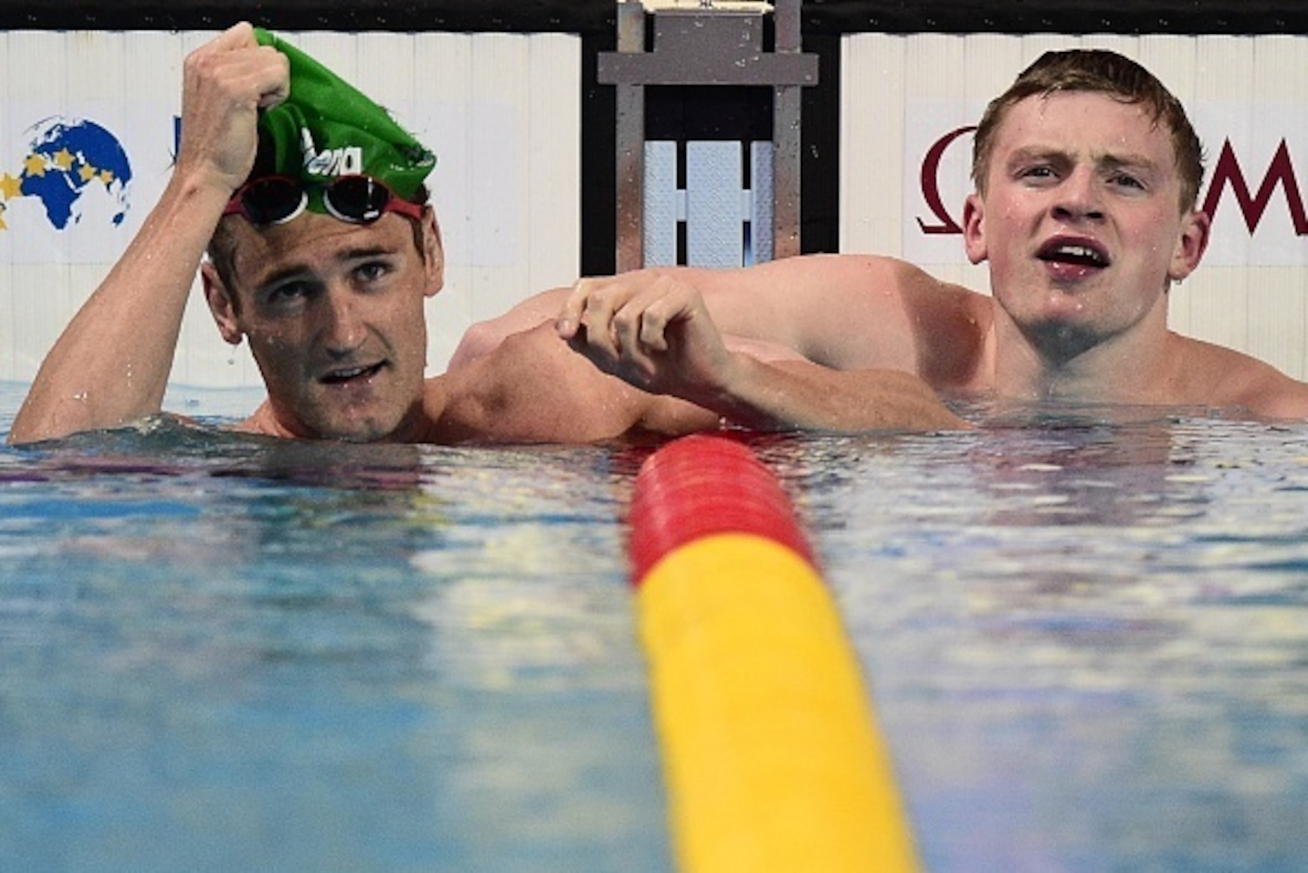 Great Britain's Adam Peaty (R) reacts next to runner-up, South Africa's Cameron Van der Burgh, after winning the final of the men's 100m breaststroke swimming event at the 2015 FINA World Championships in Kazan on August 3, 2015.   AFP PHOTO / MARTIN BURE