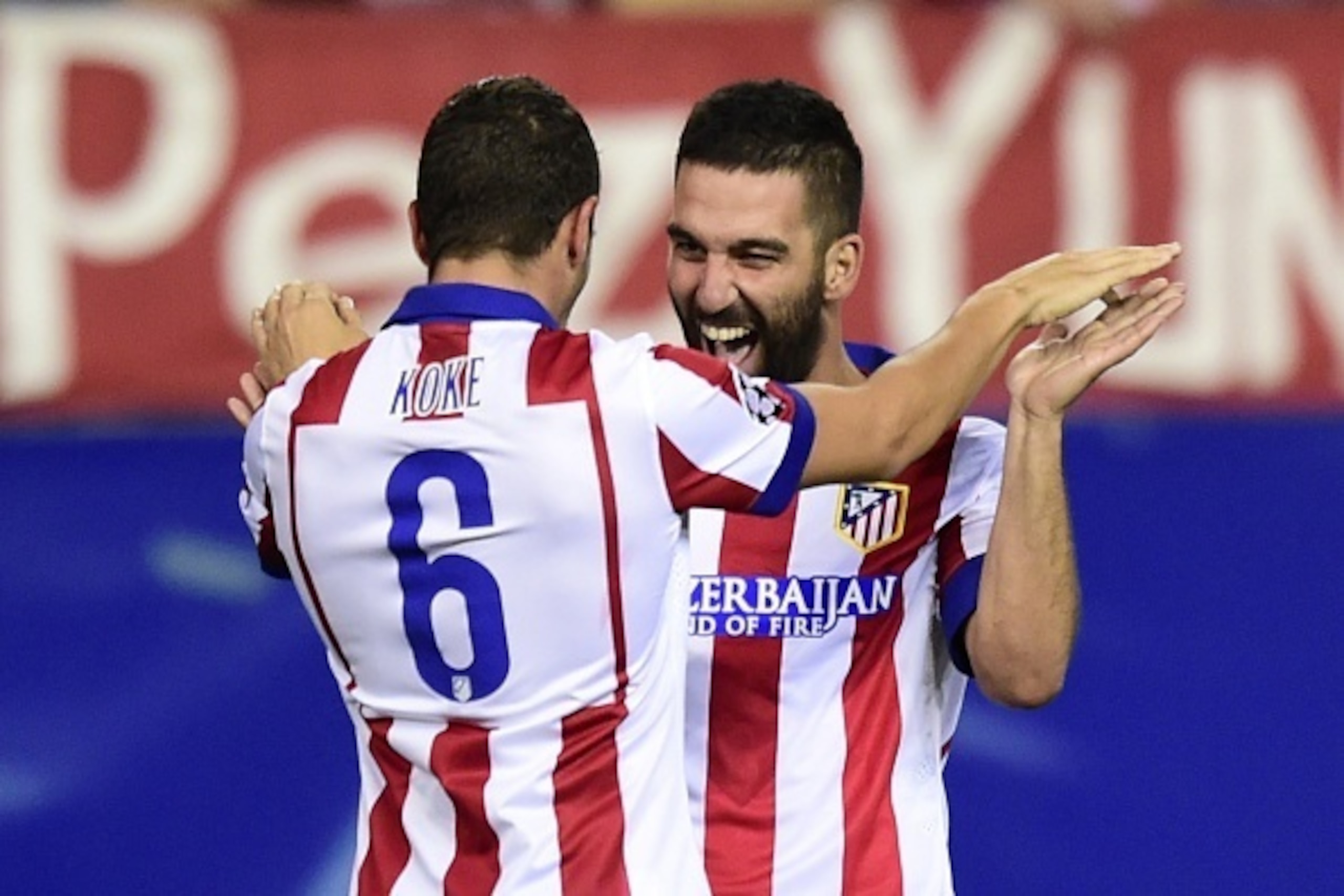 Atletico Madrid's midfielder Koke (L) and Atletico Madrid's Turkish midfielder Arda Turan celebrate after scoring during the UEFA Champions League football match Club Atletico de Madrid vs Malmo FF at the Vicente Calderon stadium in Madrid on October 22, 