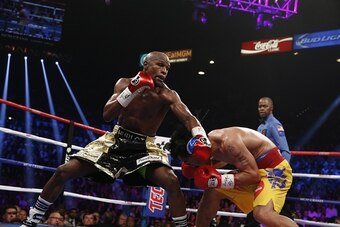 Floyd Mayweather Jr. exchange punches with Manny Pacquiao during their welterweight unification championship bout, May 2, 2015 at MGM Grand Garden Arena in Las Vegas, Nevada.  Mayweather defeated Pacquiao by unanimous decision.  AFP PHOTO / JOHN GURZINKSI