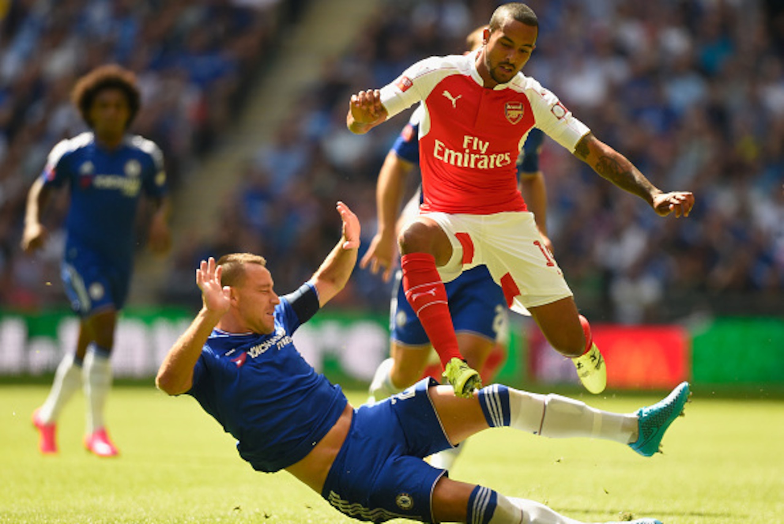 LONDON, ENGLAND - AUGUST 02:  Theo Walcott of Arsenal hurdles a challenge from John Terry of Chelsea during the FA Community Shield match between Chelsea and Arsenal at Wembley Stadium on August 2, 2015 in London, England.  (Photo by Mike Hewitt/Getty Ima
