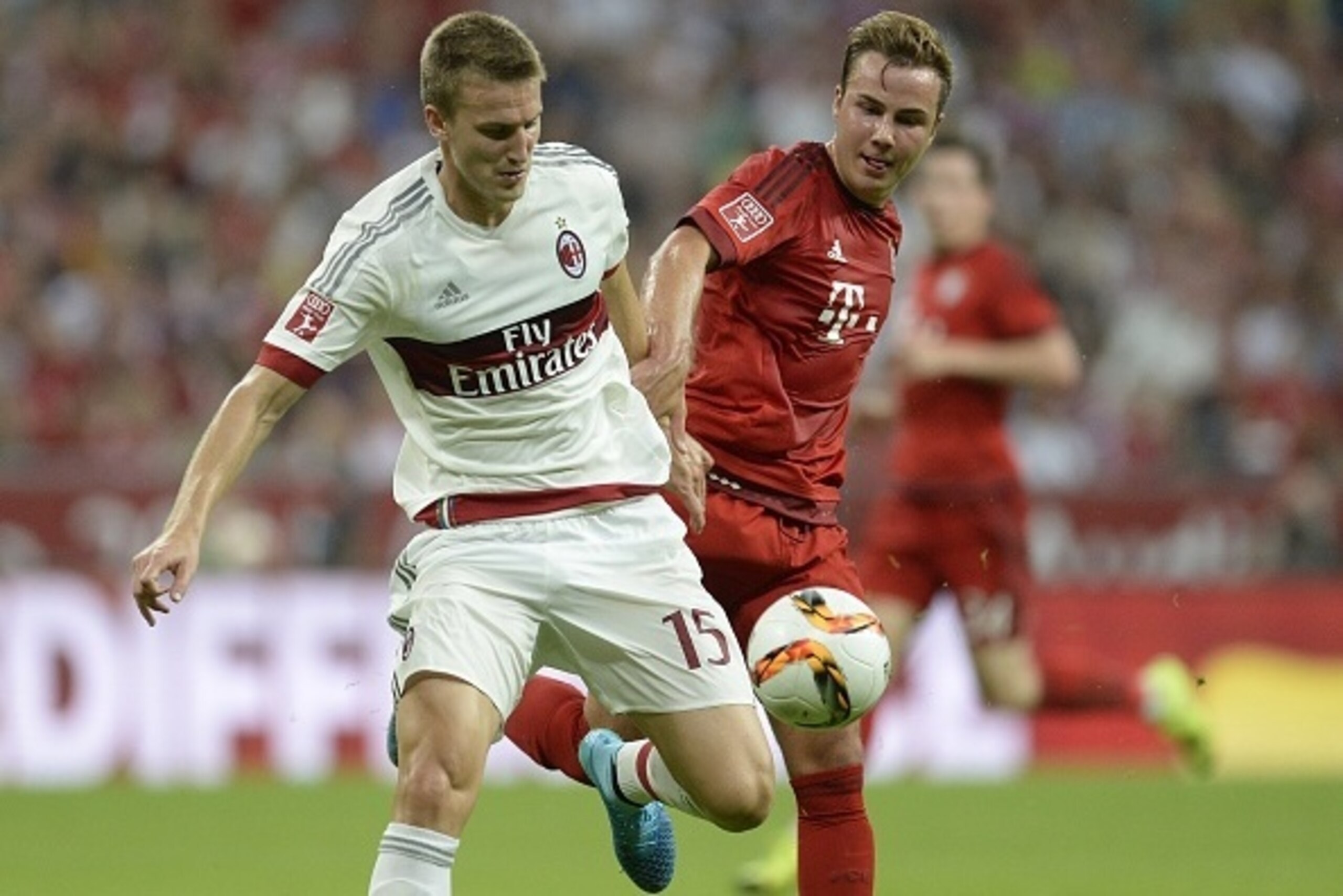 AC Milan's defender Rodrigo Ely (L) and Bayern Munich's midfielder Mario Goetze vie for the ball during the Audi Cup football match FC Bayern Munich vs AC Milan in Munich, southern Germany, on August 4, 2015. The Audi Cup football matches with Bayern Muni