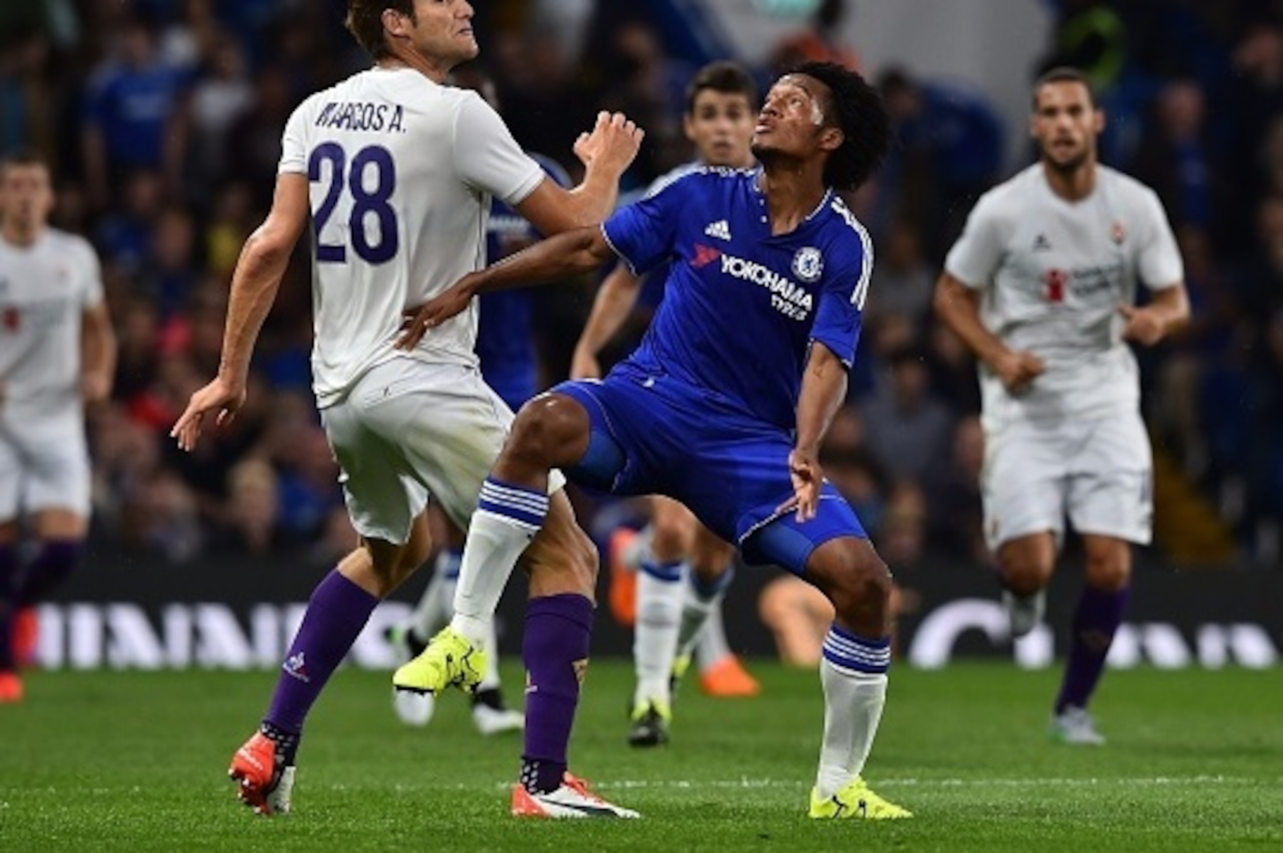 Fiorentina's Spanish defender Marcos Alonso (L) contests a high ball with Chelsea's Colombian midfielder Juan Cuadrado (R) during the pre-season friendly International Champions Cup football match between Chelsea and Fiorentina at Stamford Bridge in Londo