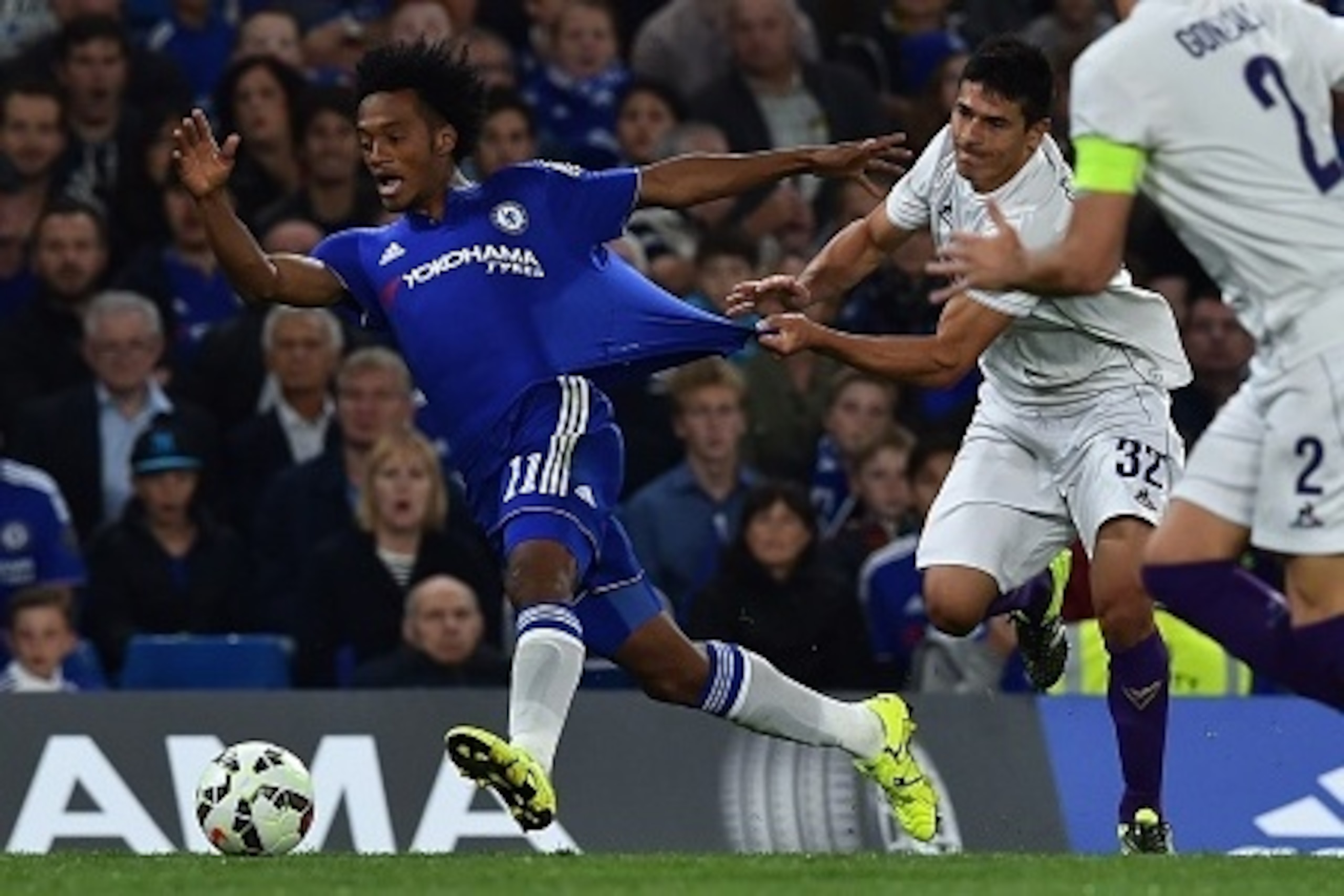 Chelsea's Colombian midfielder Juan Cuadrado (L) has his shirt pulled by Fiorentina's Argentinian defender Facundo Roncaglia (C) during the pre-season friendly International Champions Cup football match between Chelsea and Fiorentina at Stamford Bridge in