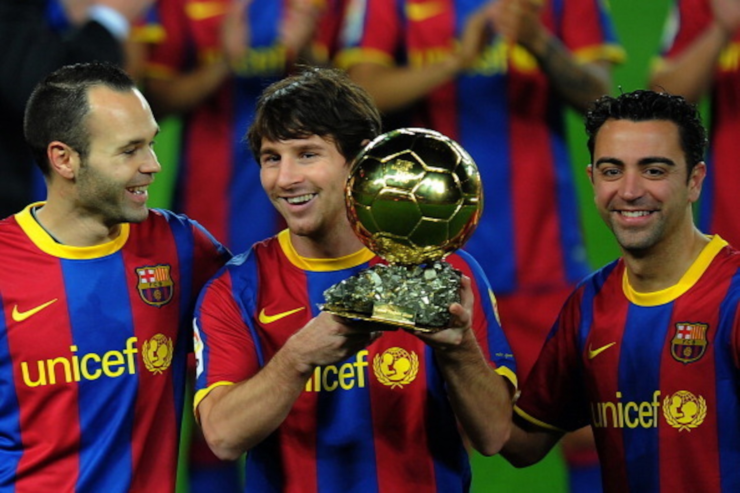 Barcelona's Argentinian forward Lionel Messi (C), flanked with Barcelona's midfielder Xavi Hernandez (R) and Barcelona's midfielder Andres Iniesta (L), poses with the 2010 Ballon d'Or trophy (Golden Ball) for the best European footballer of the year prior