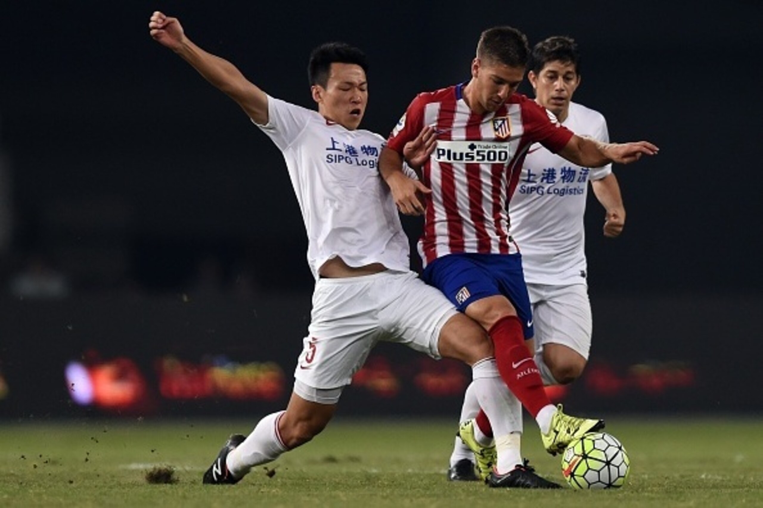 Atletico Madrid's Argentina forward Luciano Vietto (C) is challenged by Shanghai's midfielder Jiajie Wang (L) and Argentinian forward Dario Conca (R) during a friendly football match between Shanghai SIPG and Atletico Madrid in Shanghai on August 4, 2015.