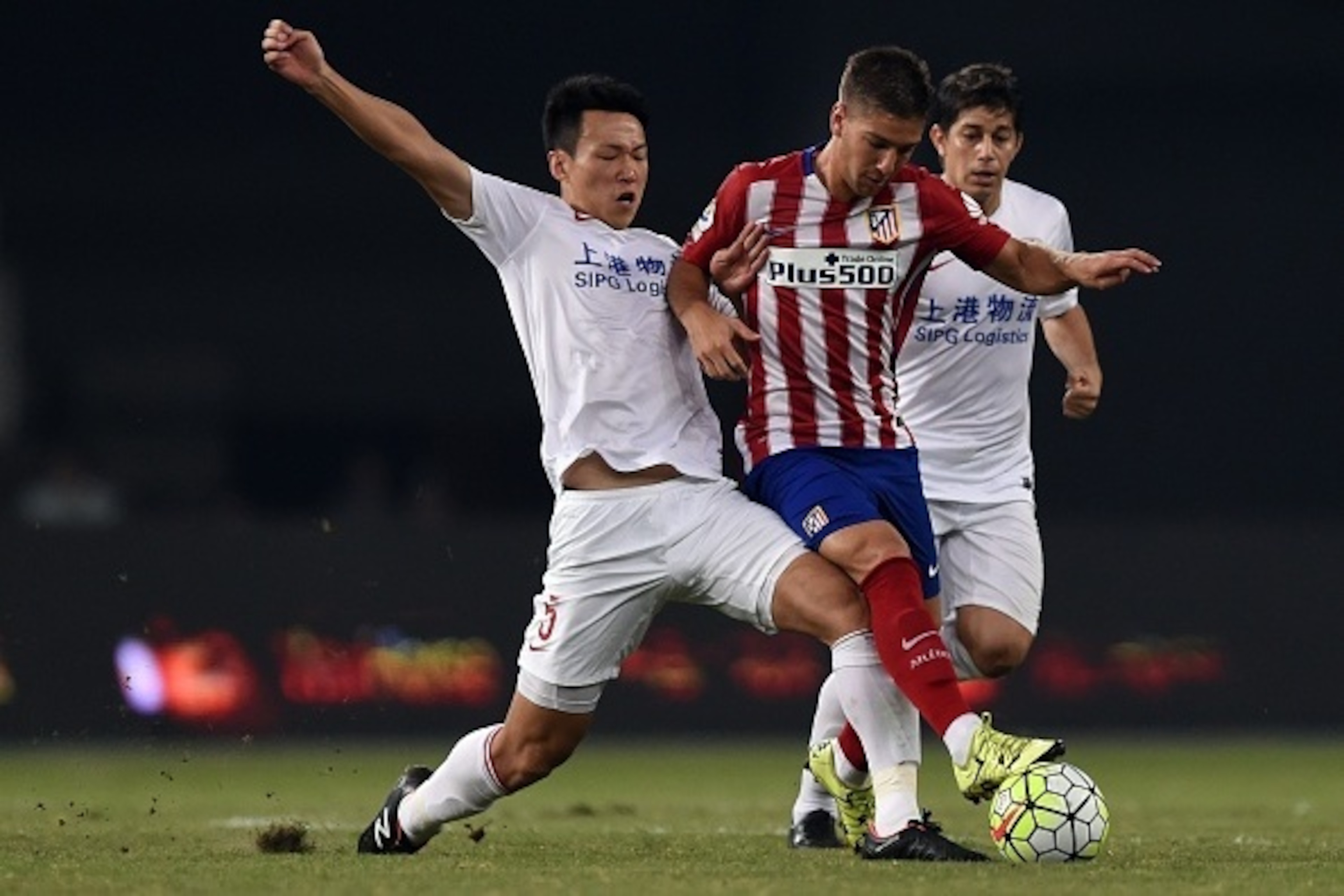 Atletico Madrid's Argentina forward Luciano Vietto (C) is challenged by Shanghai's midfielder Jiajie Wang (L) and Argentinian forward Dario Conca (R) during a friendly football match between Shanghai SIPG and Atletico Madrid in Shanghai on August 4, 2015. Atletico Madrid's Argentina forward Luciano Vietto (C) is challenged by Shanghai's midfielder Jiajie Wang (L) and Argentinian forward Dario Conca (R) during a friendly football match between Shanghai SIPG and Atletico Madrid in Shanghai on August 4, 2015.