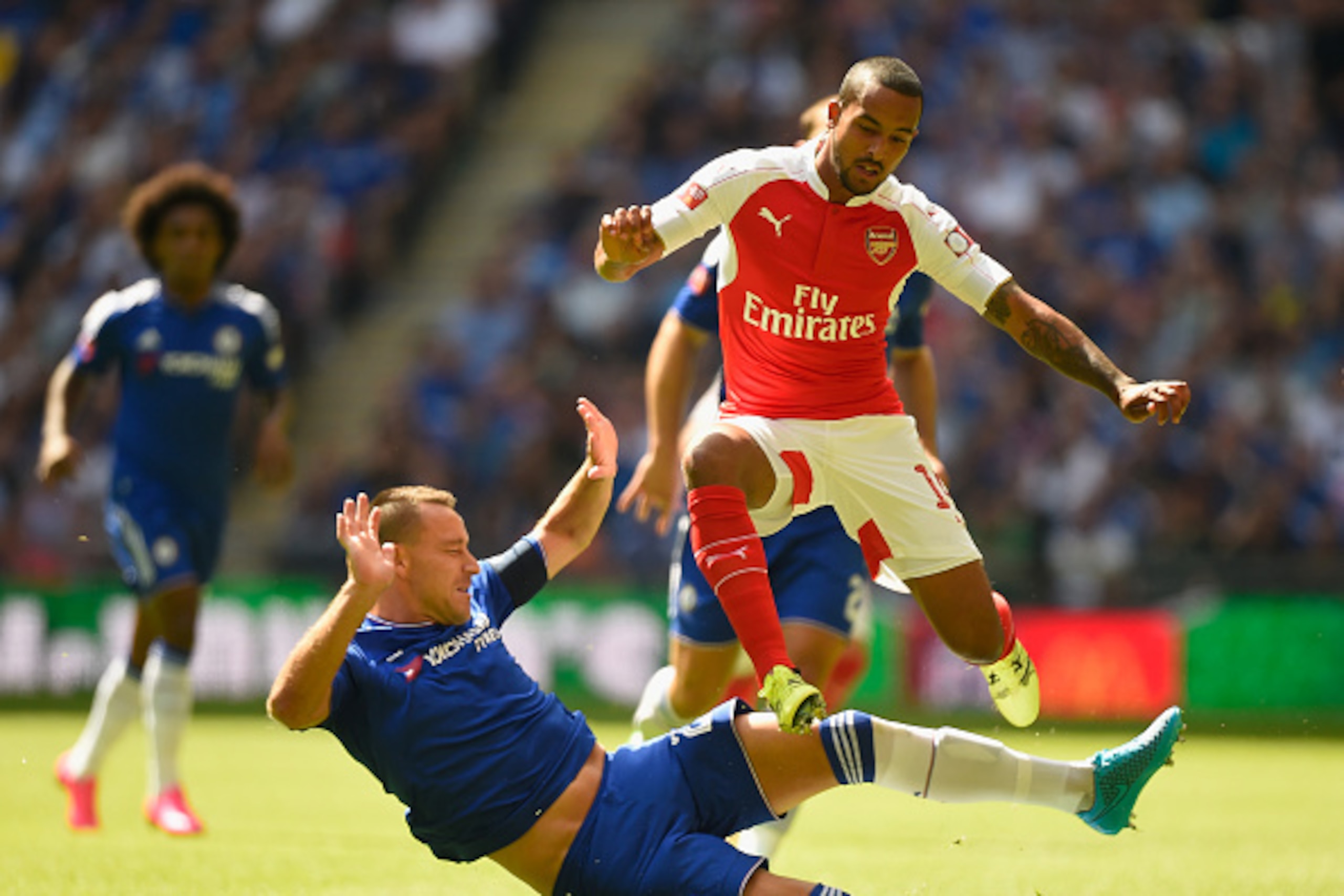 LONDON, ENGLAND - AUGUST 02: Theo Walcott of Arsenal hurdles a challenge from John Terry of Chelsea during the FA Community Shield match between Chelsea and Arsenal at Wembley Stadium on August 2, 2015 in London, England. (Photo by Mike Hewitt/Getty Ima LONDON, ENGLAND - AUGUST 02: Theo Walcott of Arsenal hurdles a challenge from John Terry of Chelsea during the FA Community Shield match between Chelsea and Arsenal at Wembley Stadium on August 2, 2015 in London, England. (Photo by Mike Hewitt/Getty Ima